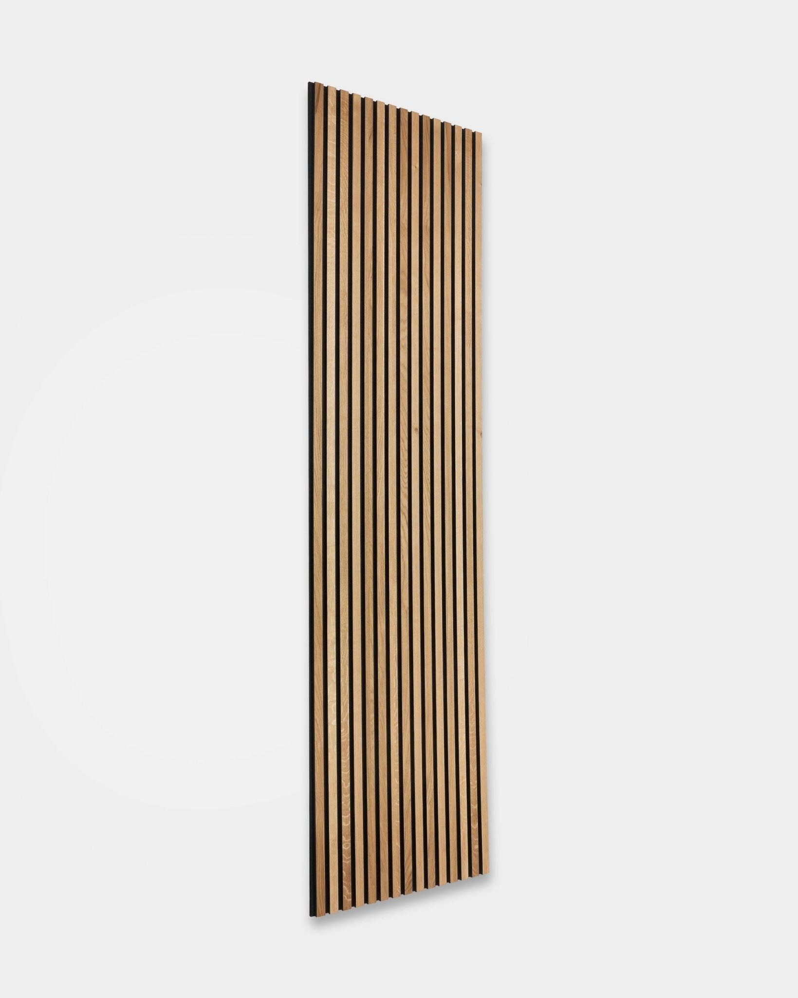 WoodUpp Akupanel Rustic in Brown Rovere (240 x 60 cm) con listelli in legno vertical e fughe acustiche scure, installato su una semplice parete bianca per un controllo del suono in stile nordico.