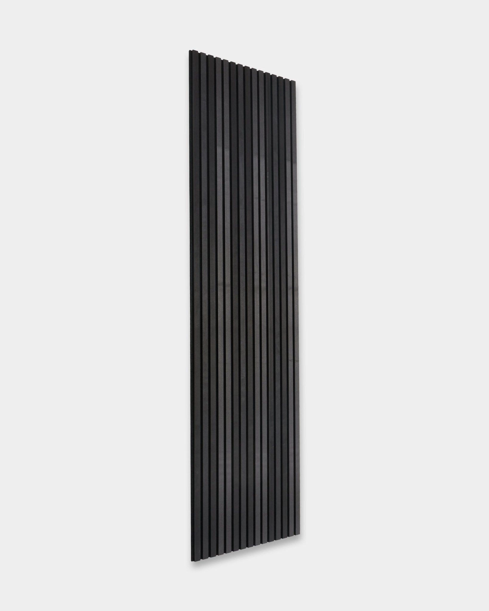 WoodUpp Akupanel Tonal Pannello acustico in Black Ash (300x60cm) con vertical doghe installato su una semplice parete grigio chiaro, in uno stile minimalista scandinavo.