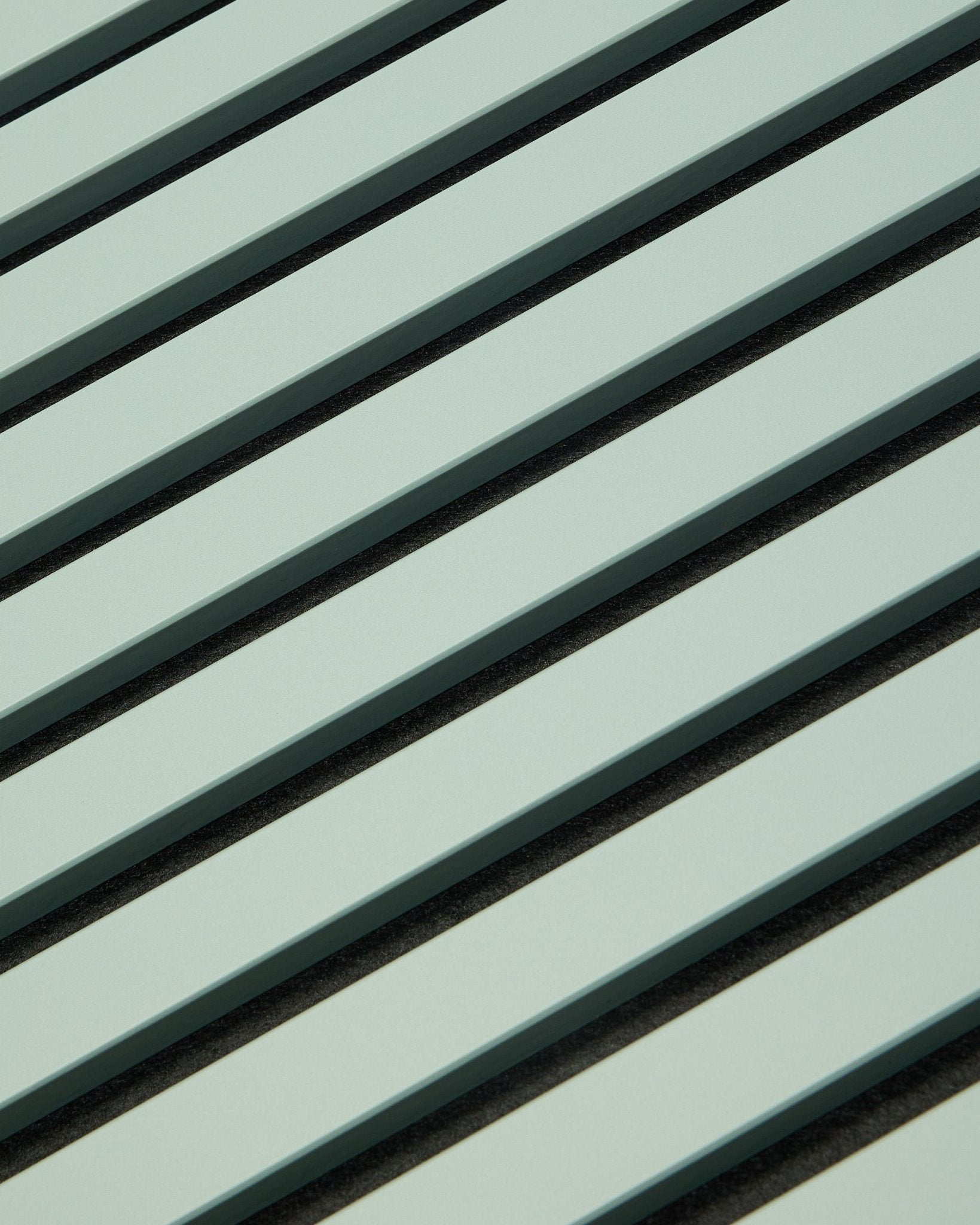 Hue | Akupanel / Cloud di WoodUpp presenta pannelli acustici in legno verde chiaro con doghe vertical e fughe scure, che creano un motivo geometrico pensato per l'assorbimento acustico.