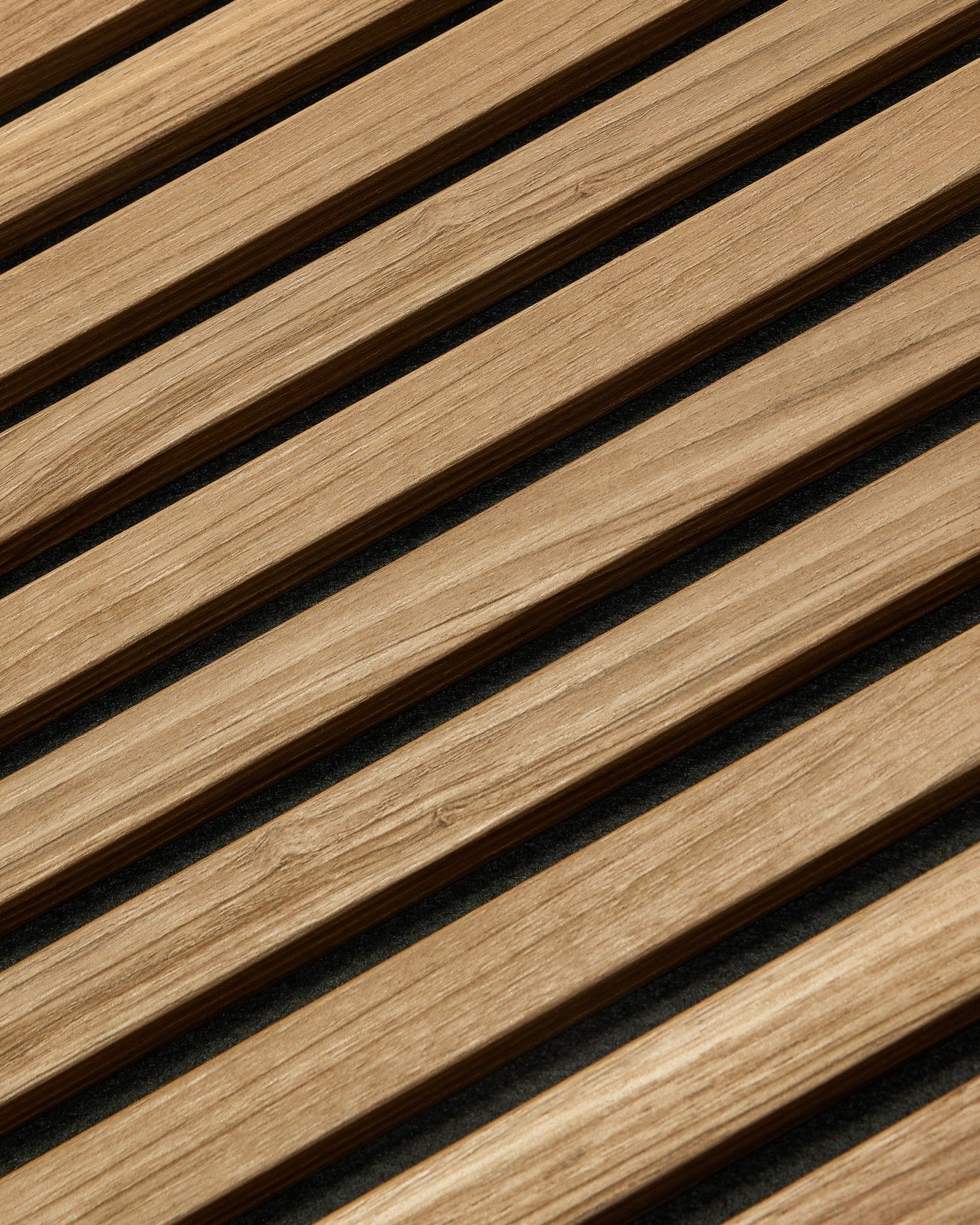 Primo piano diagonale di WoodUpp Akupanel Essential Pannello acustico in English Walnut, 240x60 cm, che mostra una finitura uniforme e uno sfondo scuro tra ogni doga in legno.