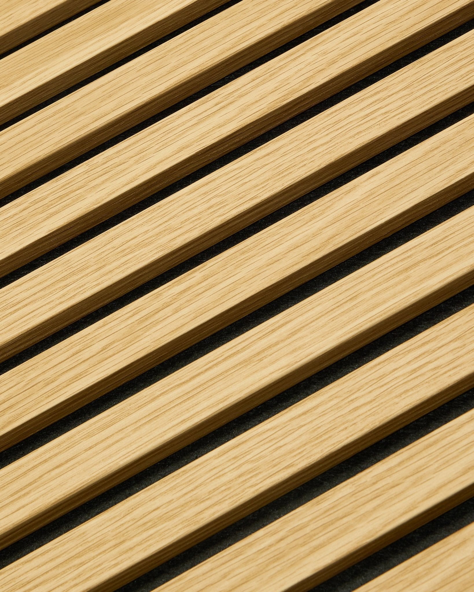 Primo piano di WoodUpp Akupanel Pannello acustico in Southern Rovere, 240x60 cm, con listelli diagonali e interspazi acustici scuri per un assorbimento del suono migliorato.