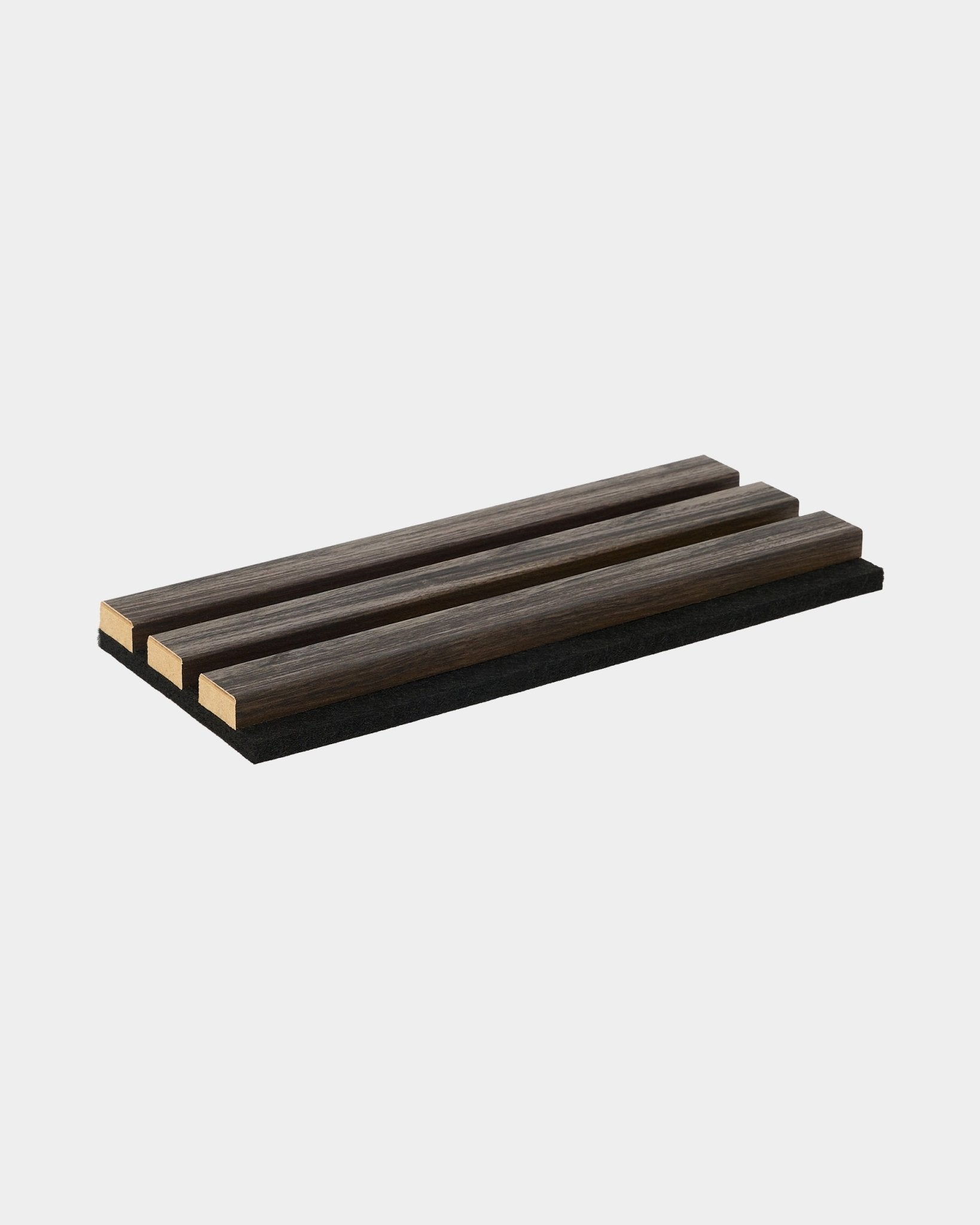 Campione WoodUpp Essential in Black Oak, un sottopentola rettangolare con tre listelli in legno, pensato per completare le collezioni di pannelli acustici in legno in stile nordico.