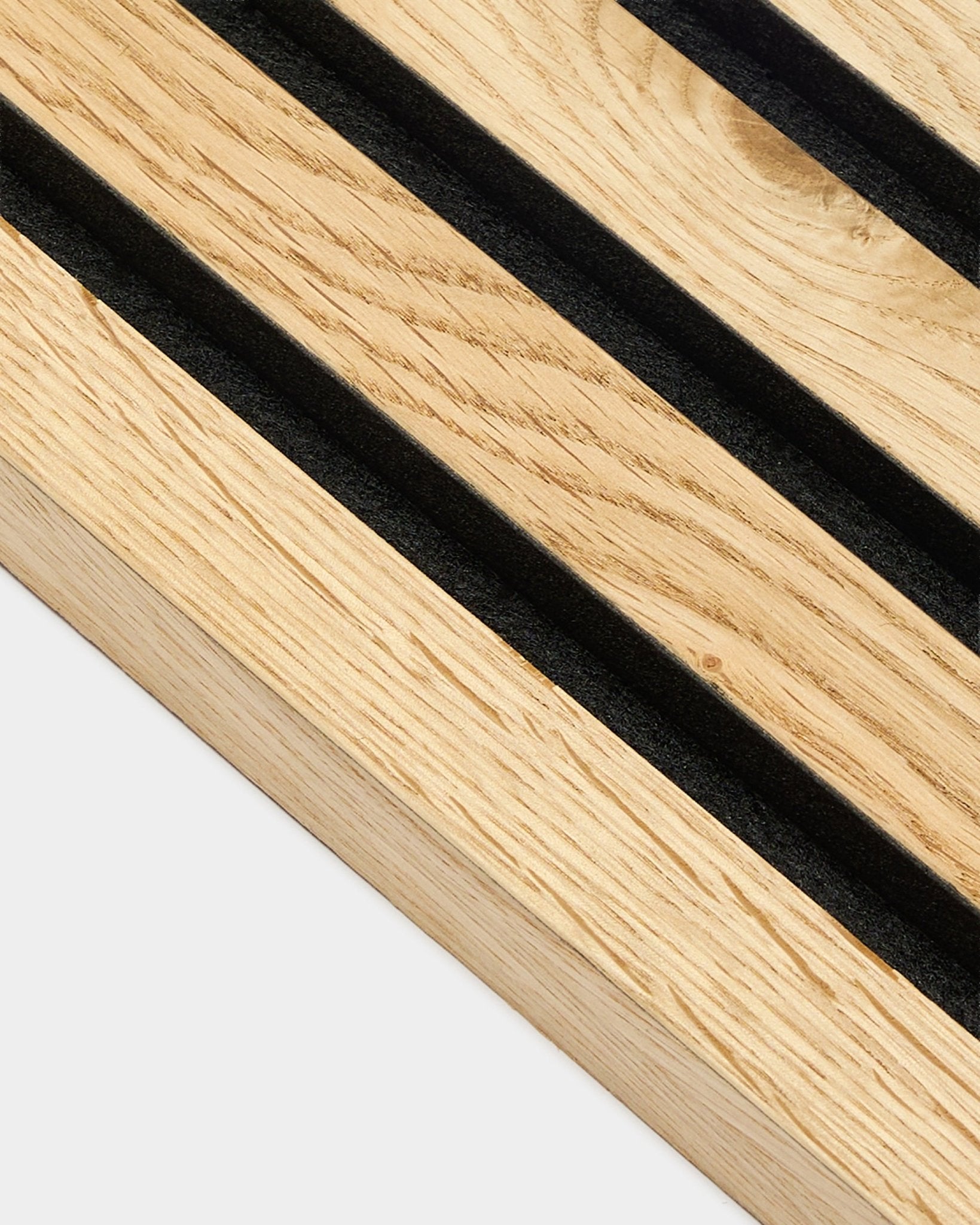 Primo piano della lamella terminale WoodUpp Akupanel in natural oak rustico, spessa 2,2 cm, con scanalature diagonali black e texture delle venature natural wood ben visibile.