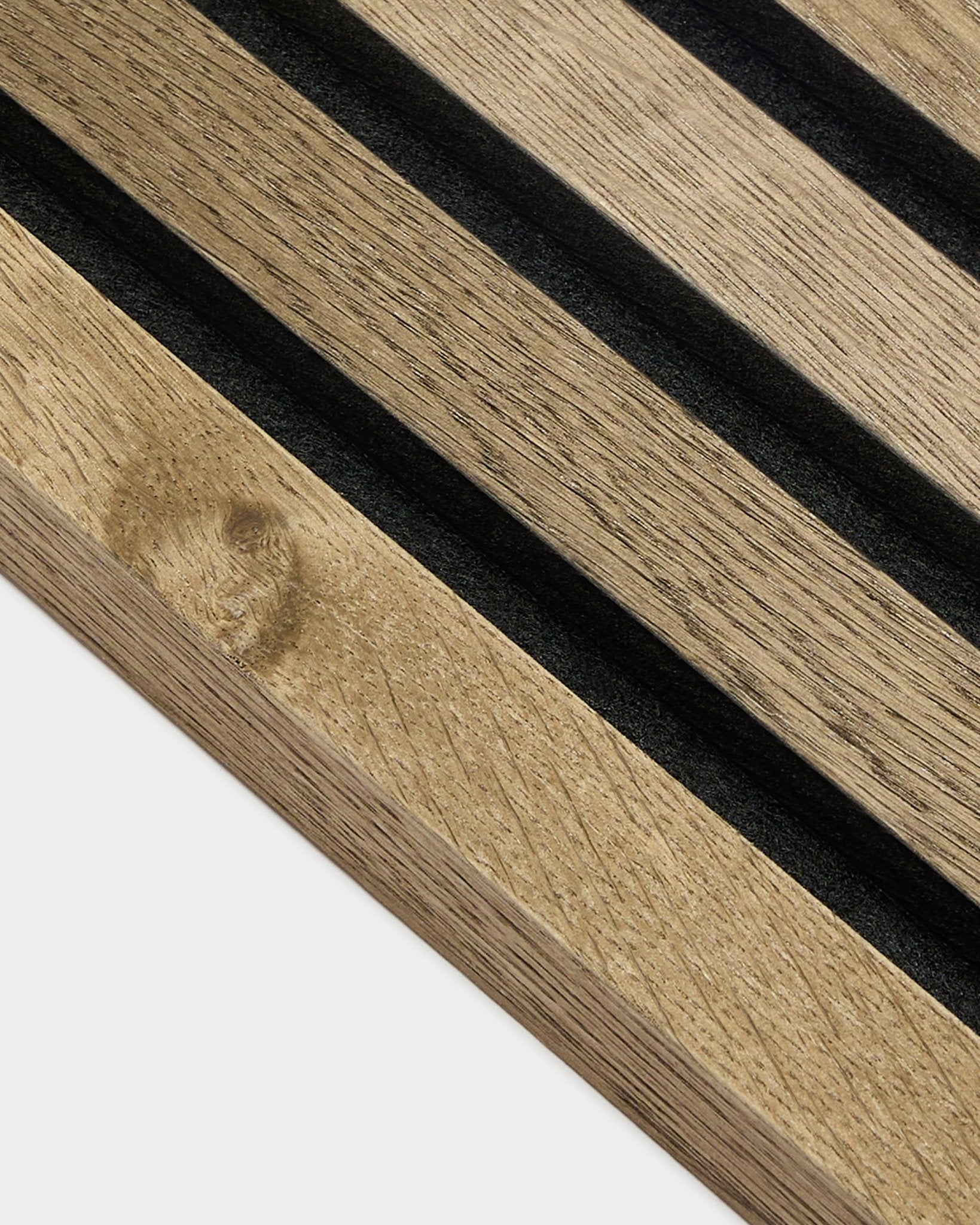 Primo piano della lamella terminale WoodUpp Akupanel in Rustic Grey Oak, MDF da 2,2 cm Pannello acustico con scanalature black e venatura del legno visibile su sfondo grigio chiaro.