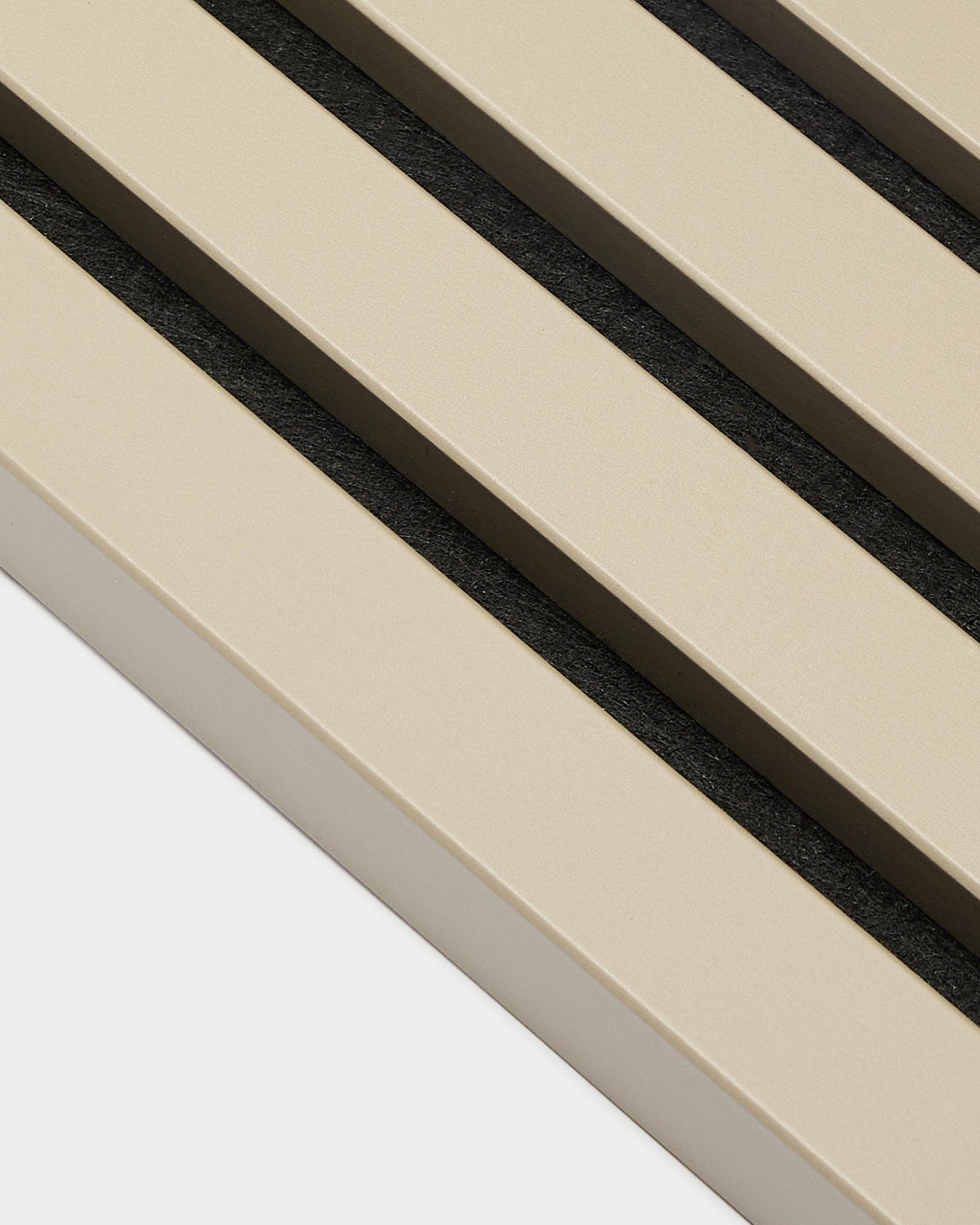 Primo piano della lamella terminale WoodUpp Akupanel in Stone, 2,2 cm—doghe acustiche beige con spazi black su supporto bianco, adatta per pareti a pannelli con telaio in MDF.