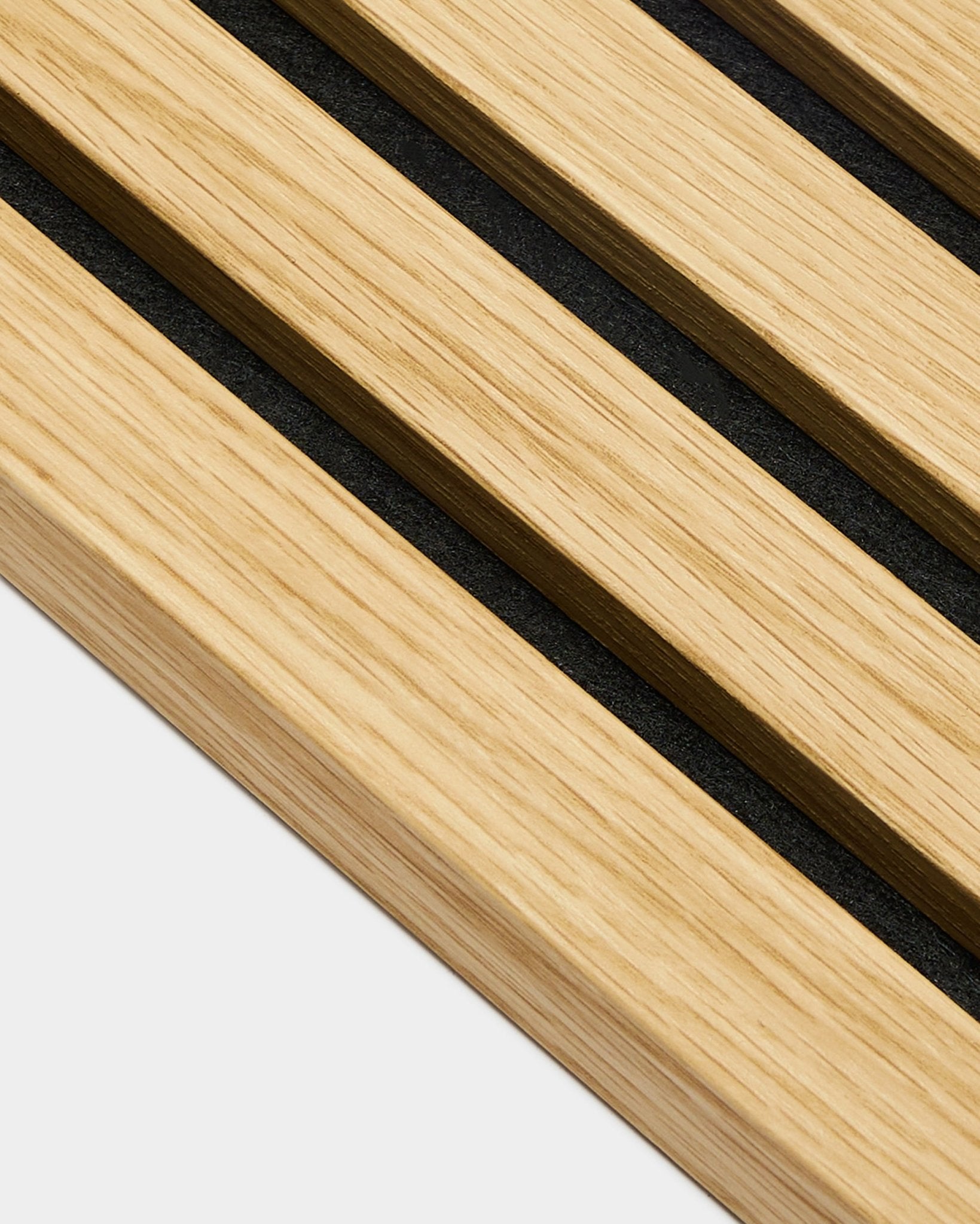 Primo piano della lamella terminale WoodUpp Akupanel in Southern Rovere, con doghe larghe 2,2 cm e spazi black, disposte in diagonale su uno sfondo chiaro grey.