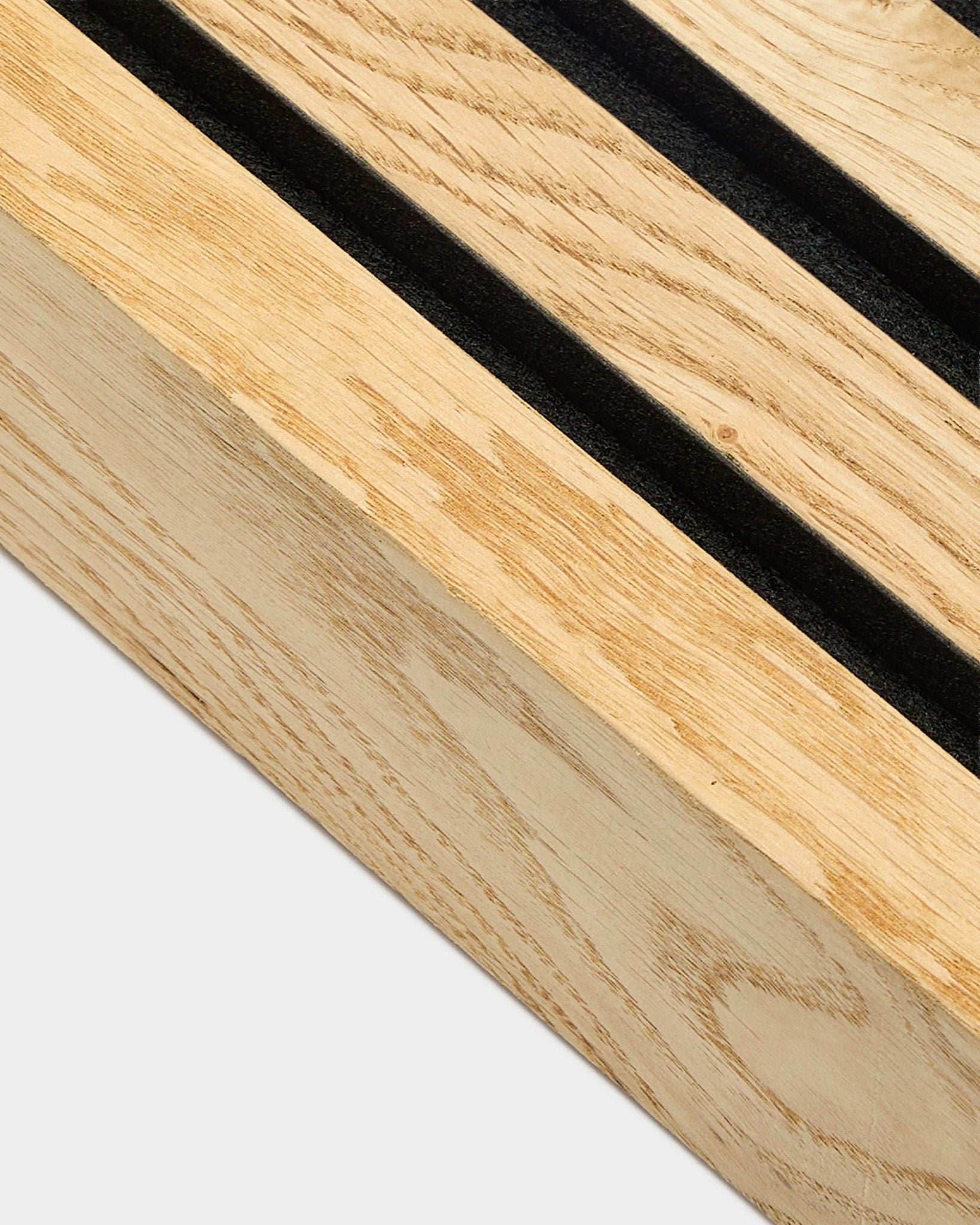Primo piano di una lamella terminale WoodUpp Akupanel in Rustic Natural Oak, 6,7 cm, con scanalature parallele black e telaio in MDF per installazione acustica a parete.