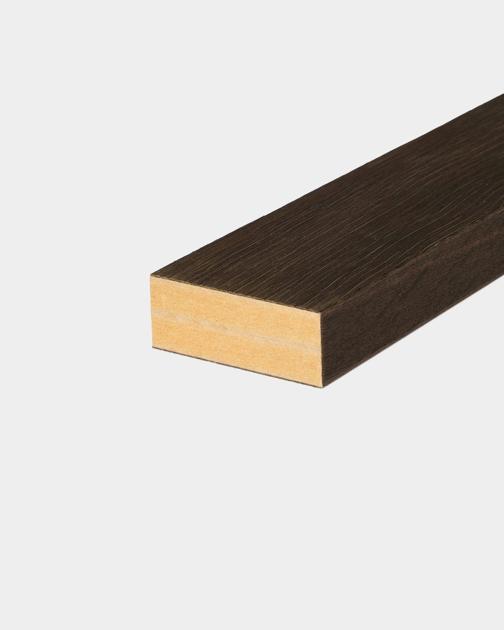 WoodUpp Akupanel end lamella: lamella acustica rettangolare in legno con i lati marrone scuro e un’estremità a vista in legno naturale su uno sfondo bianco liscio.