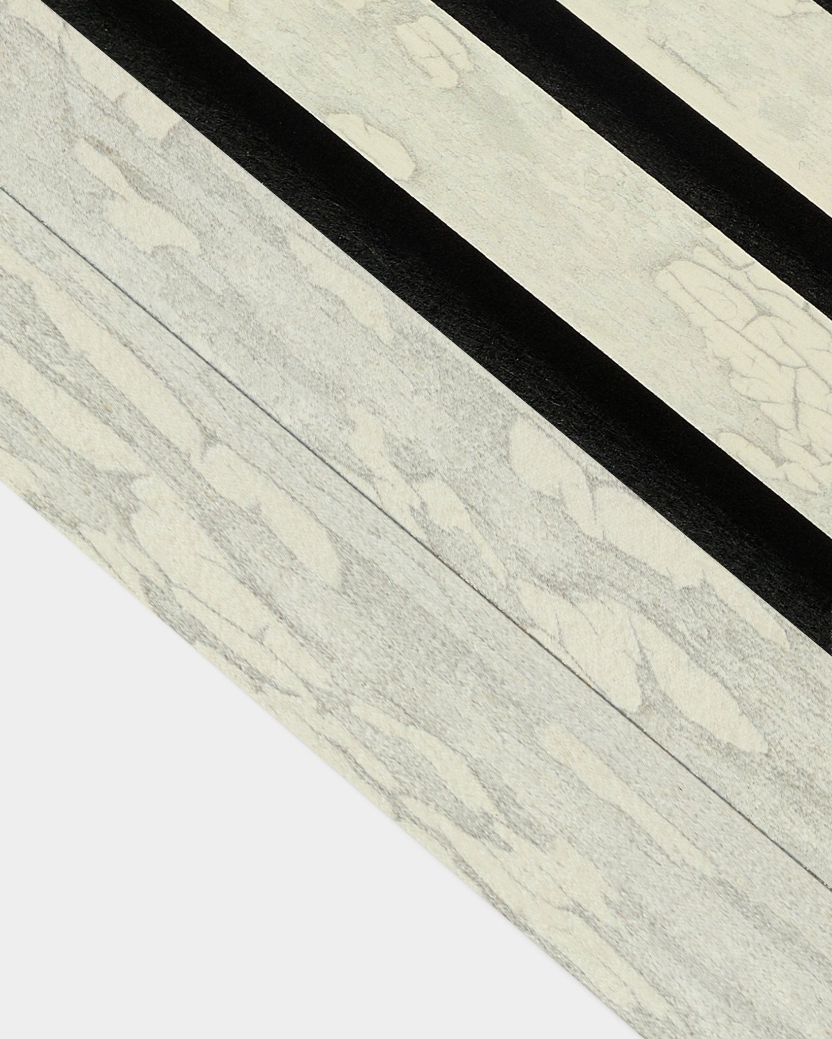 Primo piano della lamella terminale Oxide White (6,7 cm) di WoodUpp per l’installazione Akupanel Pannello acustico, con decisi motivi diagonali black in stile nordico.