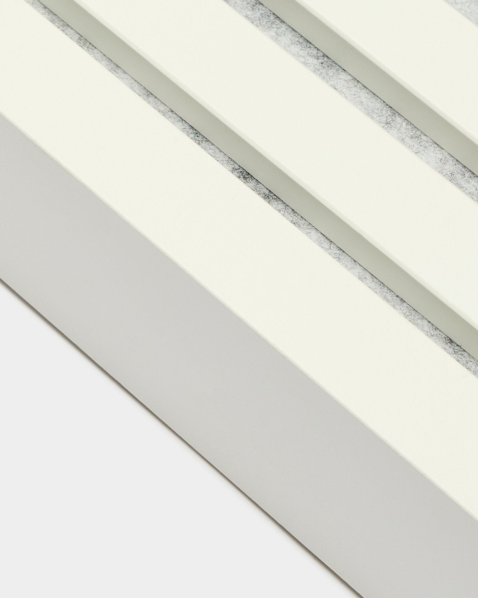 Primo piano della lamella terminale WoodUpp in Snow, larga 6,7 cm, con telaio in MDF, doppia scanalatura e finitura materica in grey per l’installazione di Akupanel Pannello acustico.