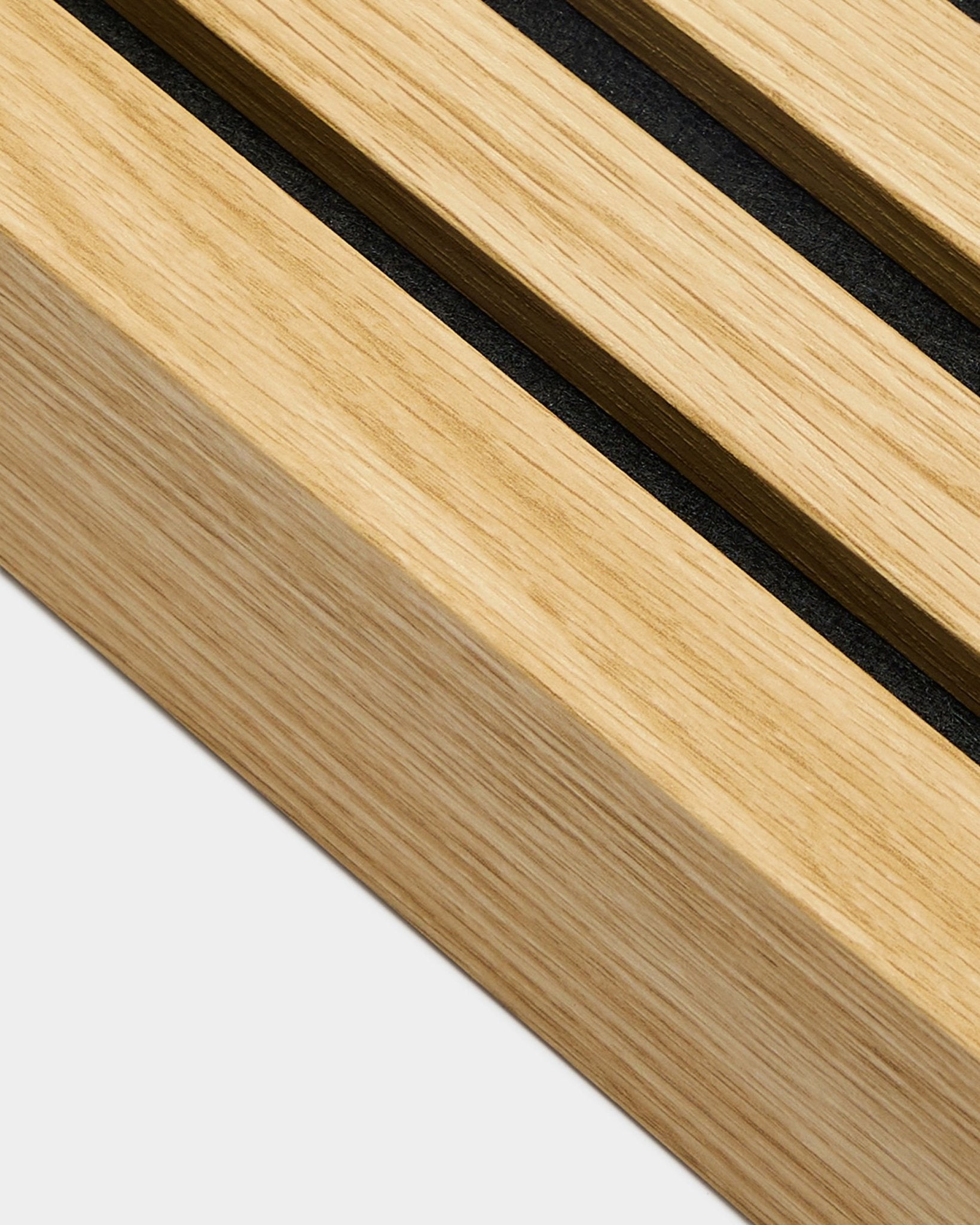 Primo piano del prodotto di installazione WoodUpp Akupanel, lamella terminale in Southern Rovere, larga 6,7 cm, con scanalature black su legno chiaro per linee Pannello acustico ben definite.