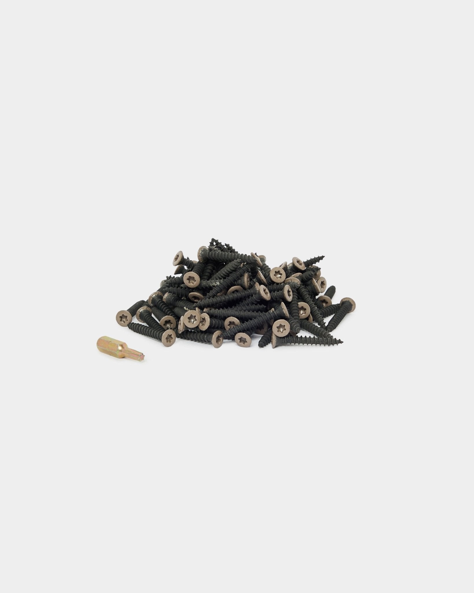 Viti di installazione WoodUpp Warm Grey (100 pz) e una punta per cacciavite dorata disposte su uno sfondo bianco, adatte per l’installazione di Pannello acustico o di accessori per pannelli.