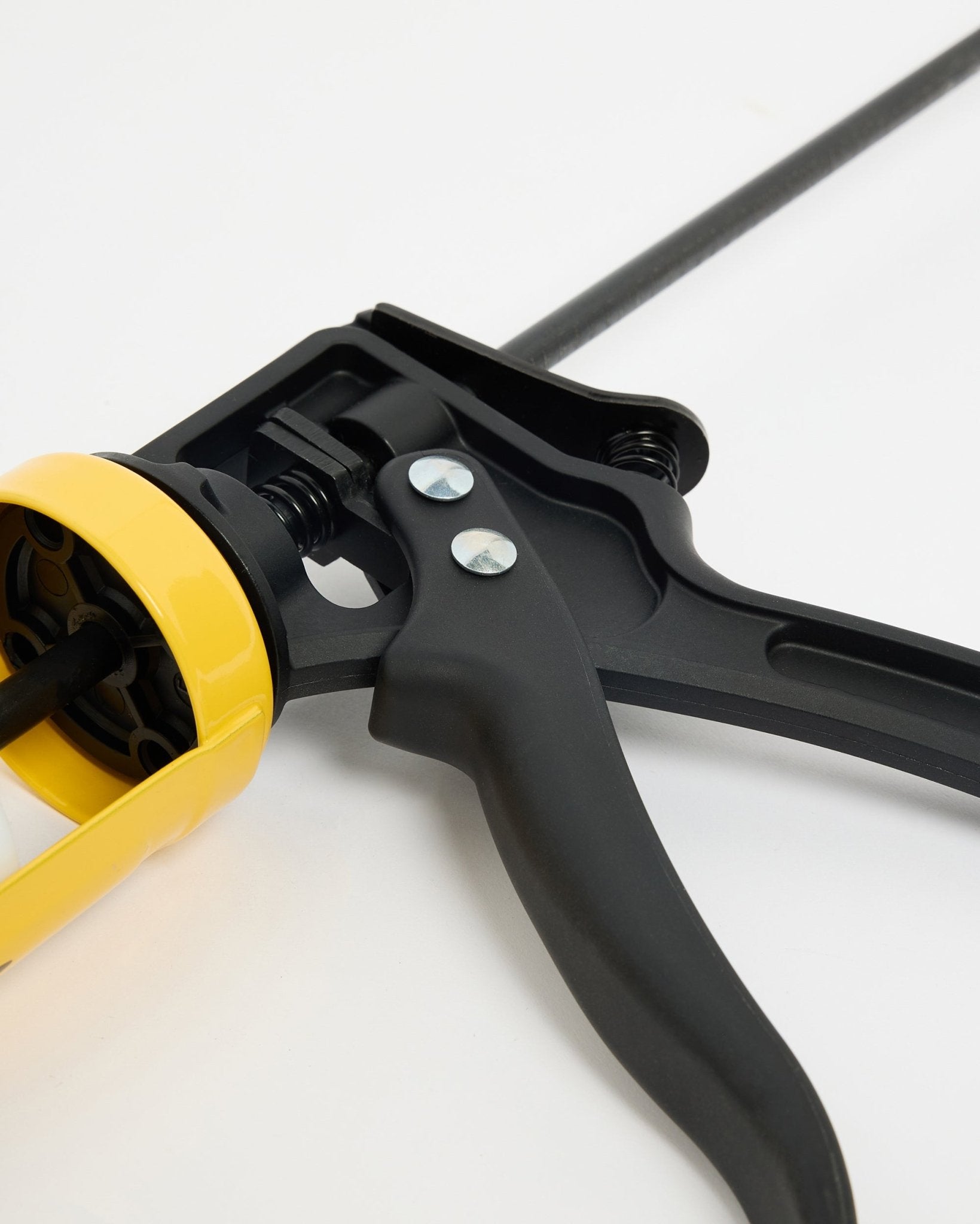 Primo piano della WoodUpp black e della Pistola per Colla gialla (290 ml), un accessorio CREATE per l’installazione di Pannello acustico Akupanel, mostrati su una superficie bianca.