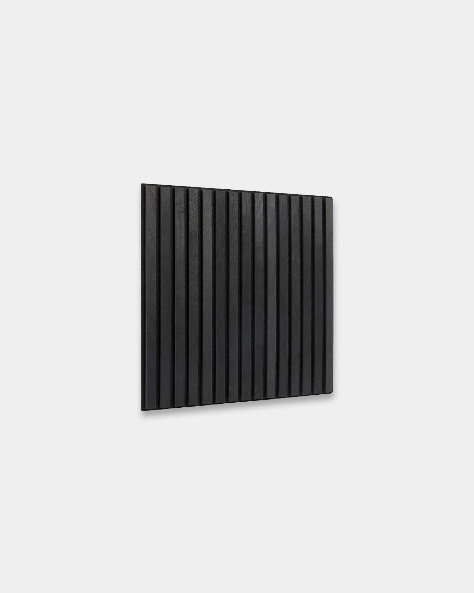 WoodUpp Akupixel Black Ash Pannello acustico (60x60 cm) con vertical doghe in legno montate su una parete grigio chiaro, espressione di un design scandinavo essenziale.
