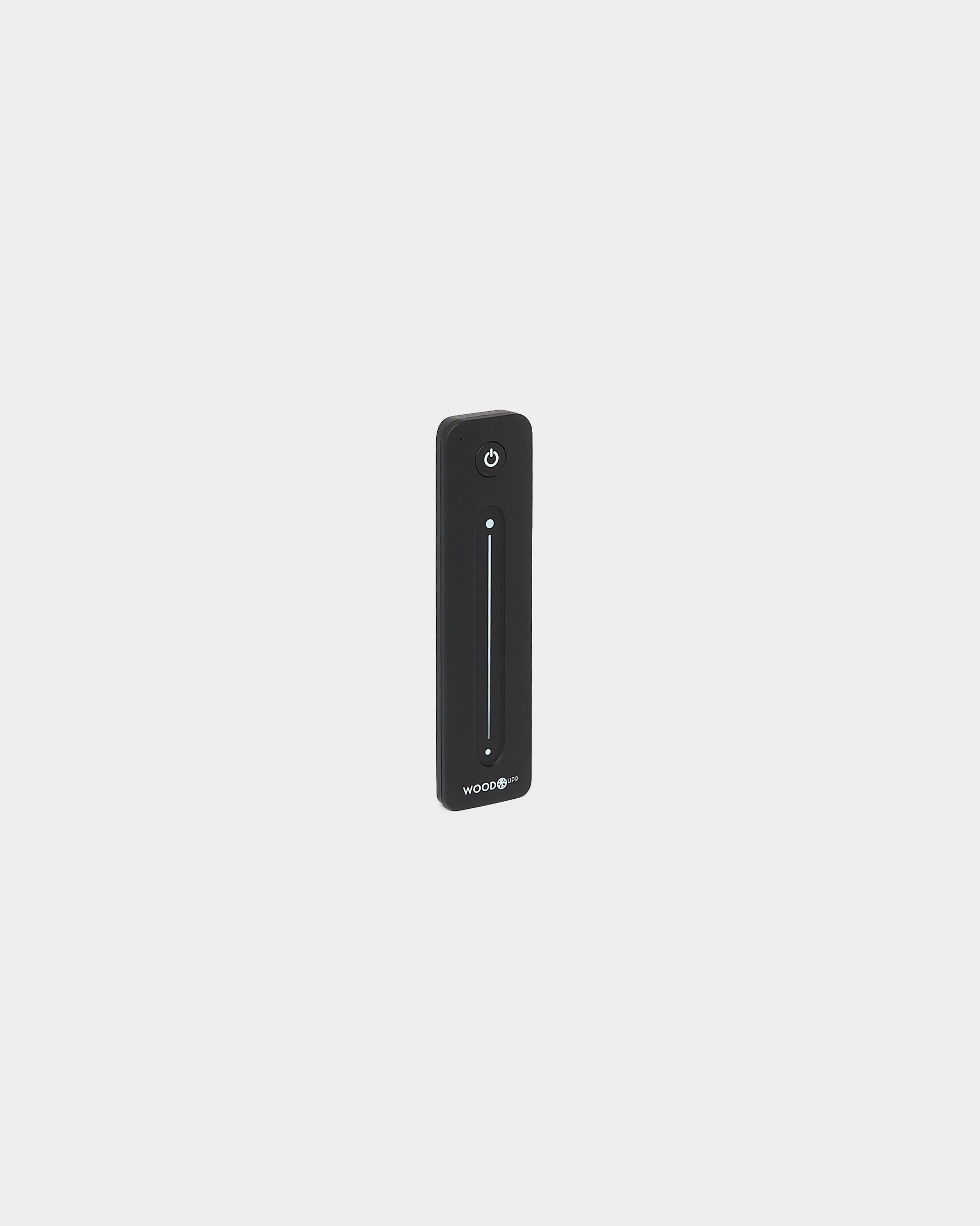 Sottile telecomando black WoodUpp Lumi per strip LED, con vertical cursore touch e pulsante di accensione, compatibile con Philips Hue, mostrato su sfondo bianco.