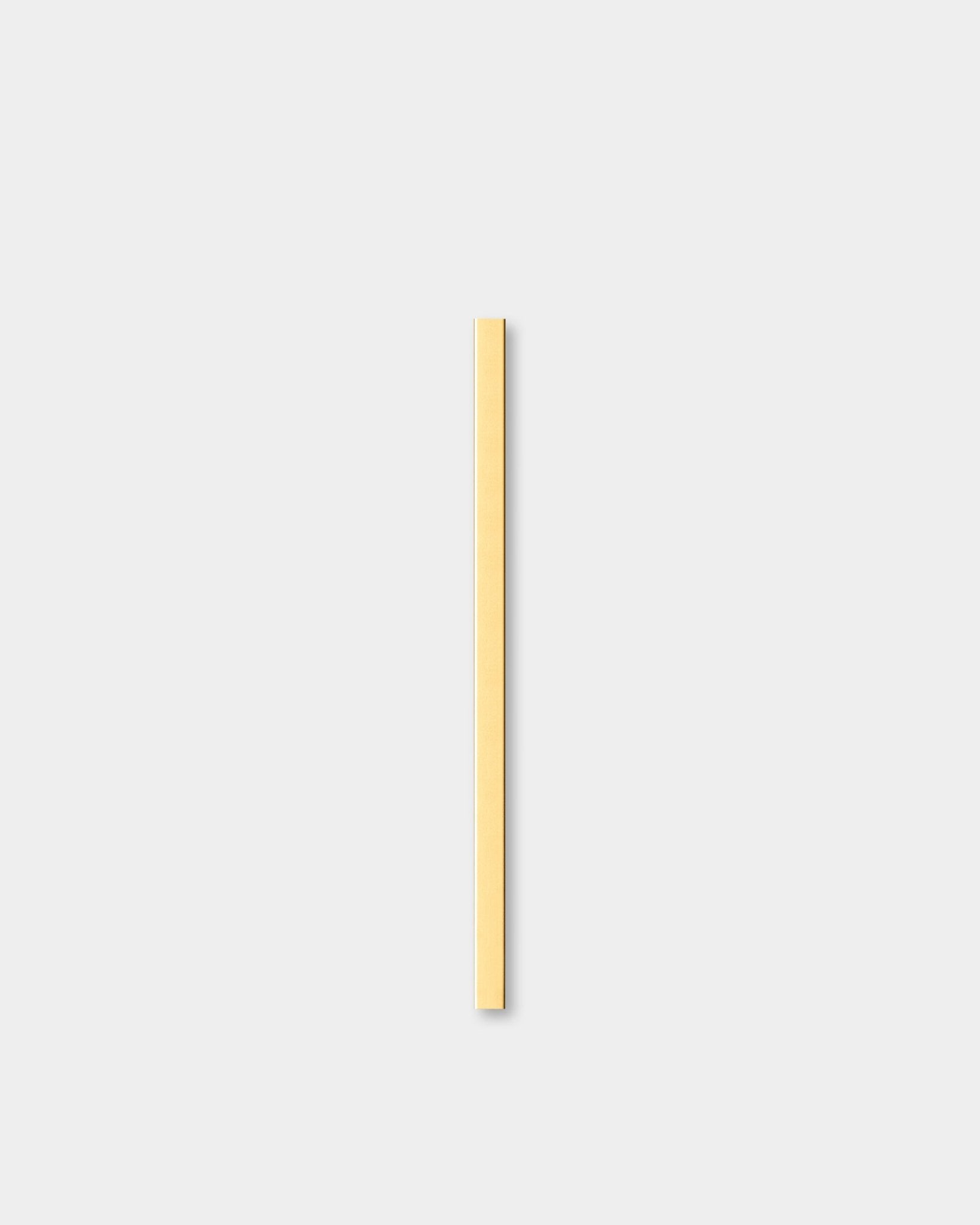 Il Liva | Cover in brass, 60 cm di WoodUpp, un Pannello acustico, è posizionato verticalmente su uno sfondo grigio chiaro accanto a una modanatura decorativa da parete.
