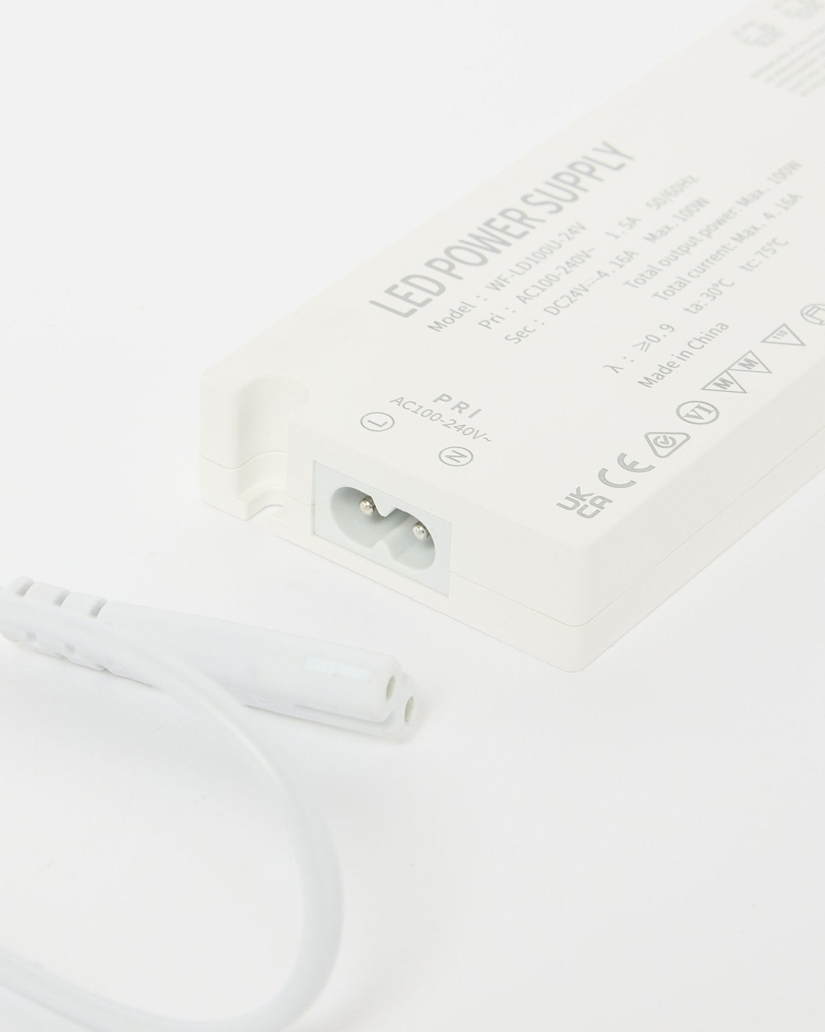 Primo piano dell'alimentatore per strisce LED WoodUpp Lumi beige (240 cm), con dettagli tecnici visibili e un cavo accanto, progettato per installazioni Nordic Pannello acustico.