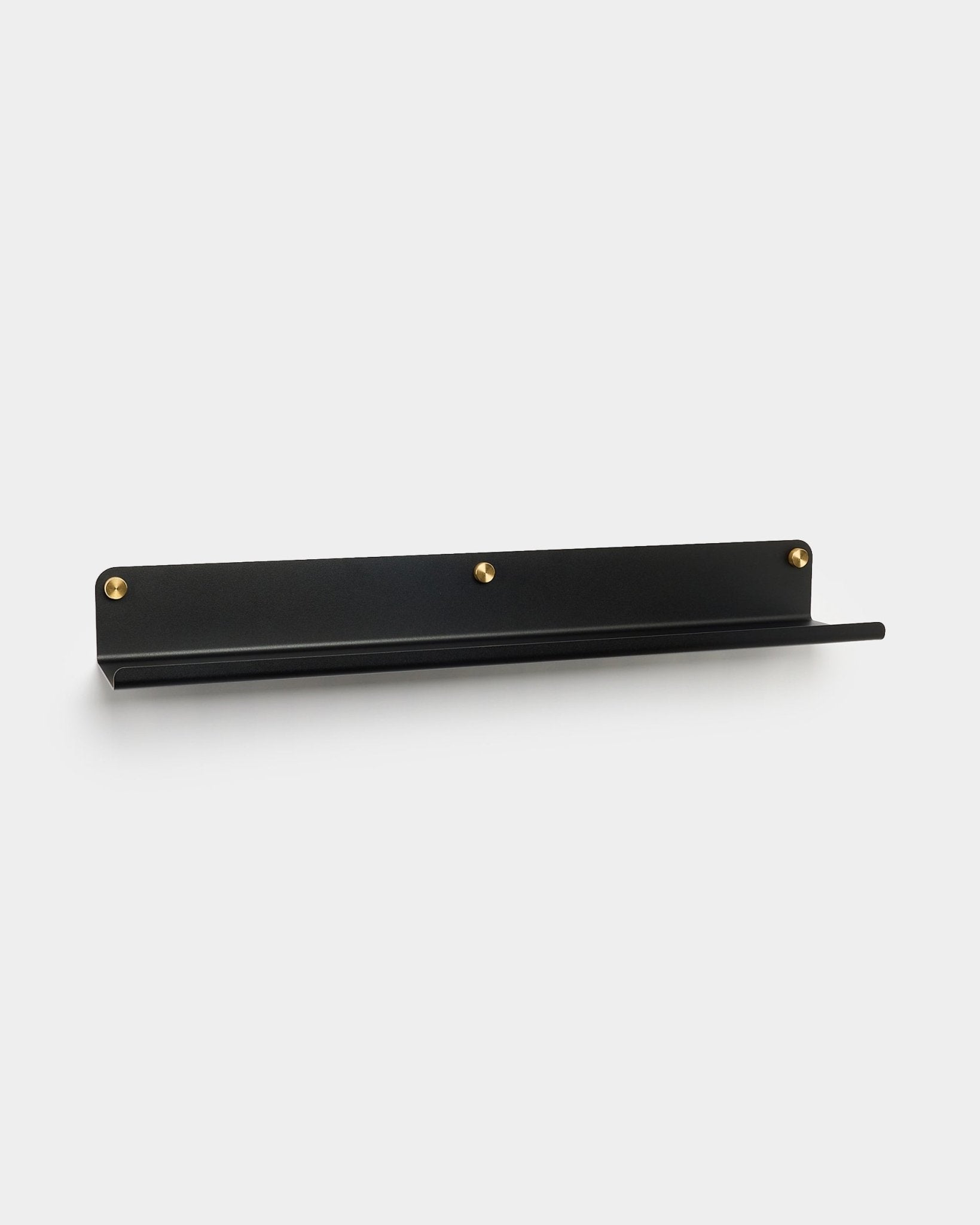 La mensola larga Norr in black (75,9 cm) di WoodUpp, realizzata in steel zincato con tre viti dorate, accessorio per Akupanel, mostrata su uno sfondo bianco uniforme.