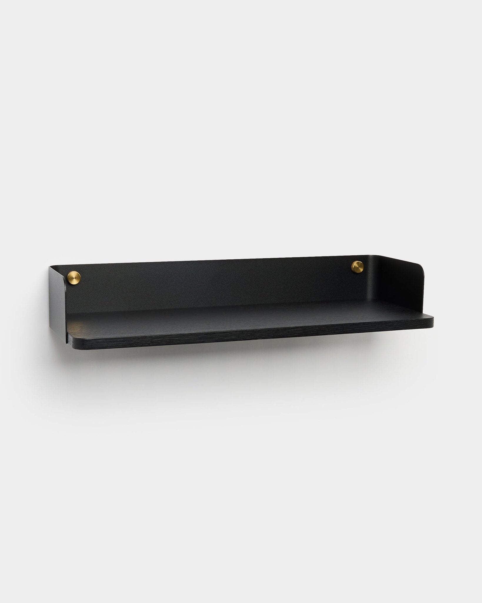 La libreria Linn di WoodUpp, un brand danese, è realizzata in metallo black con bordi rialzati e viti dorate, pensata per soluzioni di contenimento moderne.