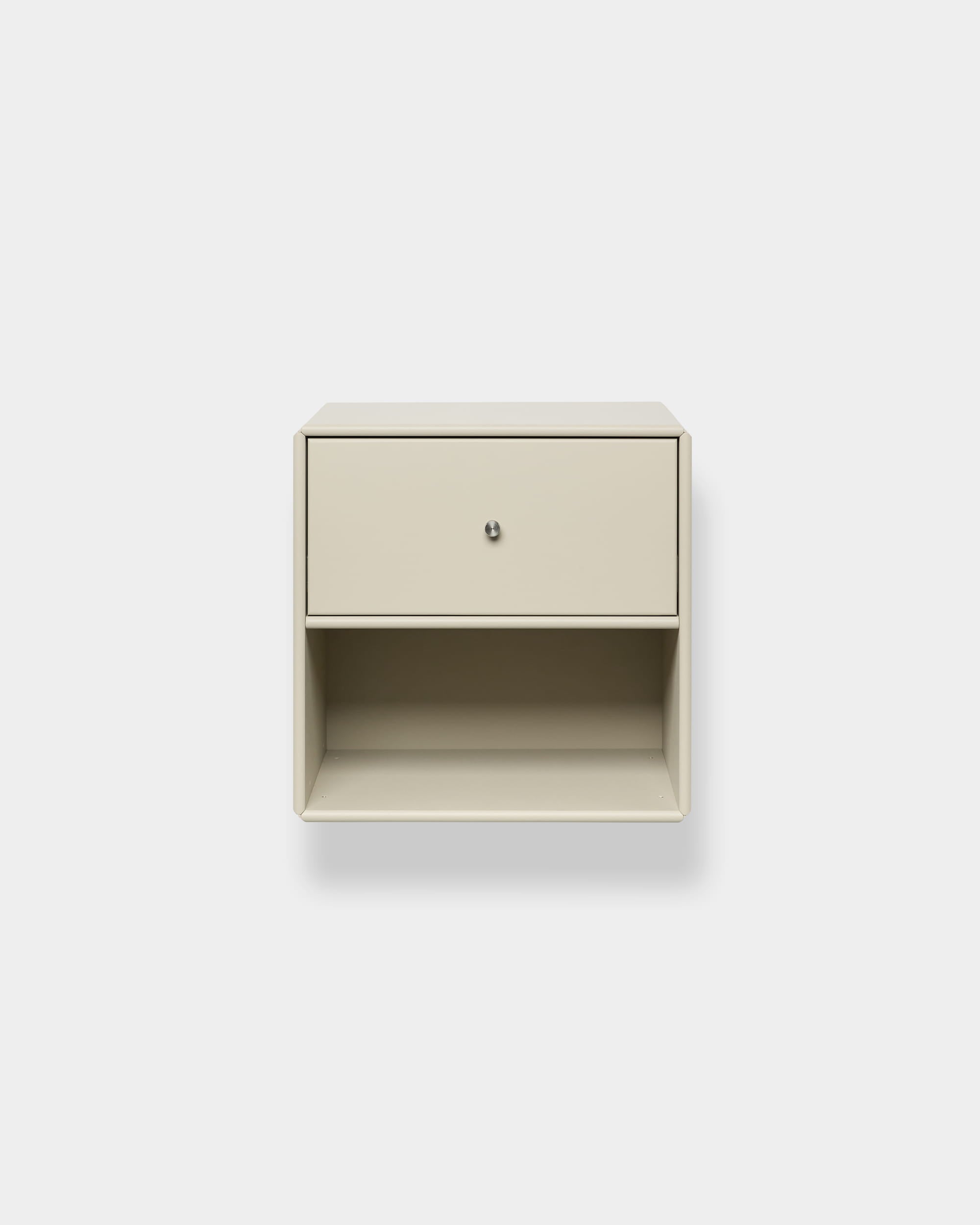 Libreria con cassetto Arka beige di WoodUpp, fissata alla parete, con cassetto superiore e ripiano aperto, vano chiuso, su uno sfondo bianco a tinta unita.