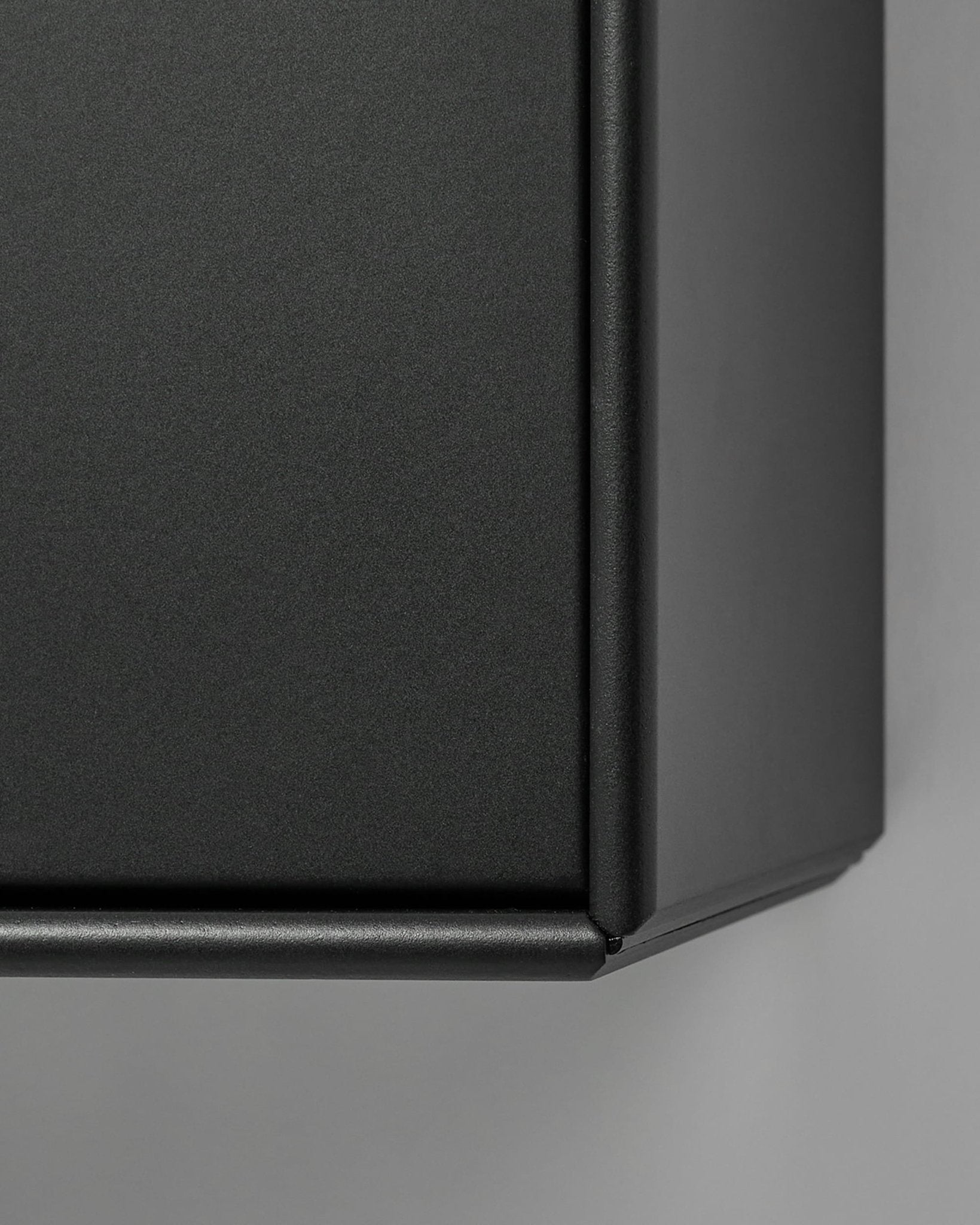 Mobile TV Arka di WoodUpp in metallo nero opaco, ripreso in primo piano su uno sfondo grigio chiaro. Il design nordico si abbina perfettamente alle collezioni di pannelli acustici in legno.