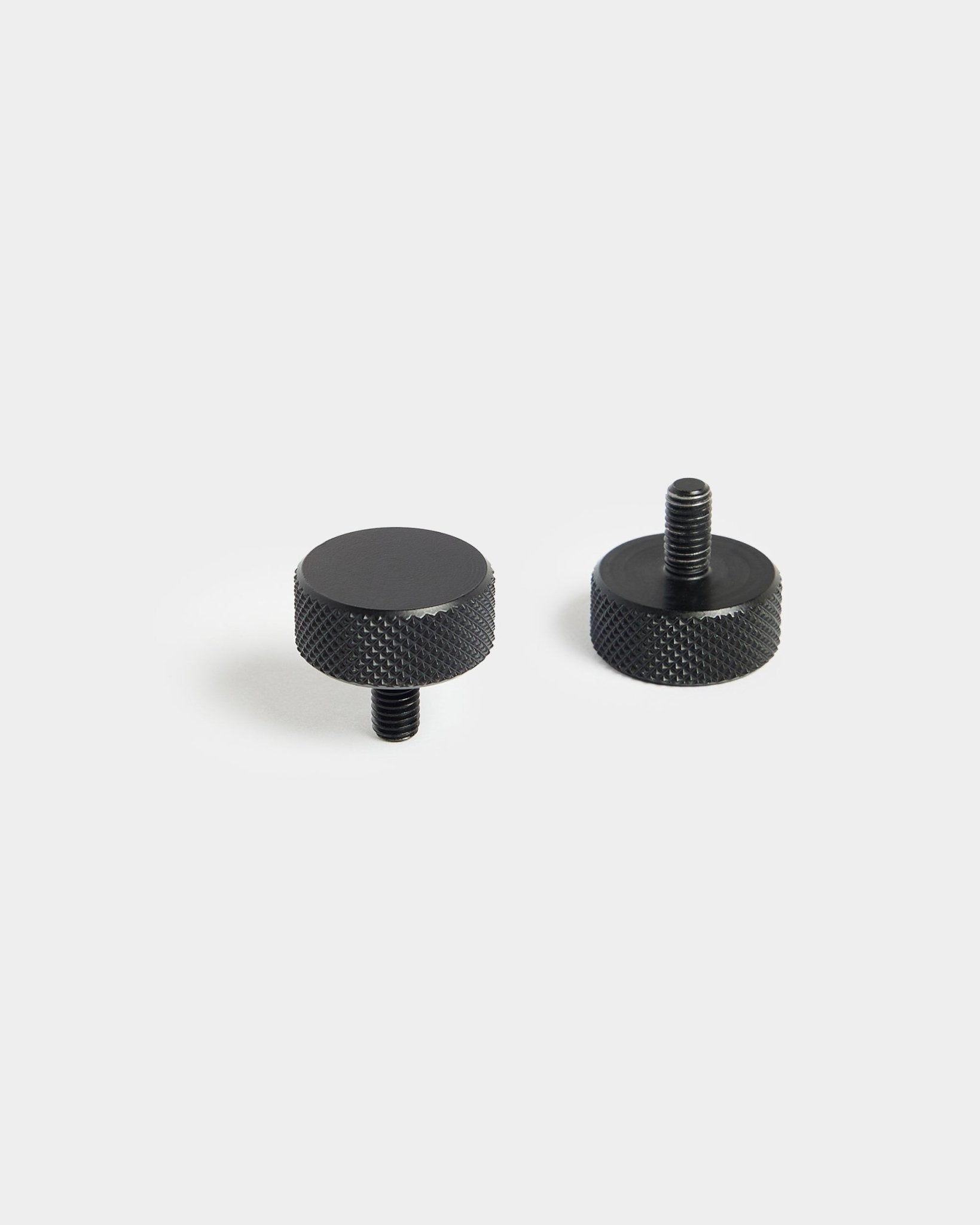 Coppia di viti Finger WoodUpp black (M5x10 mm, 20x8.8) con bordi zigrinati, progettate per l’uso con accessori Pannello acustico, su sfondo bianco semplice.