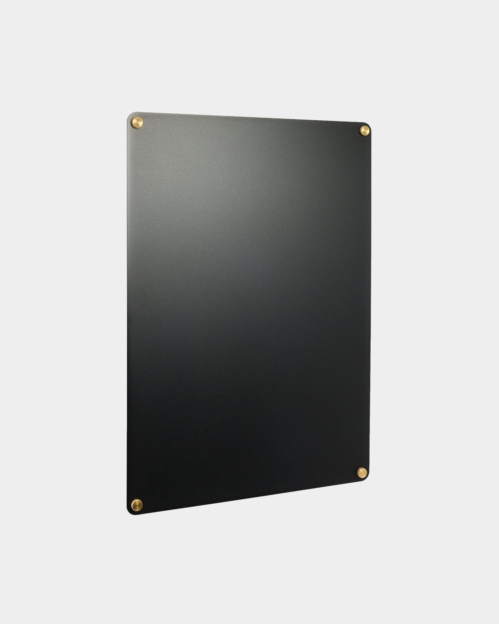 Large black Norr Lavagna magnetica di WoodUpp, parte della collezione di accessori CREATE, montata su una parete grigio chiaro.