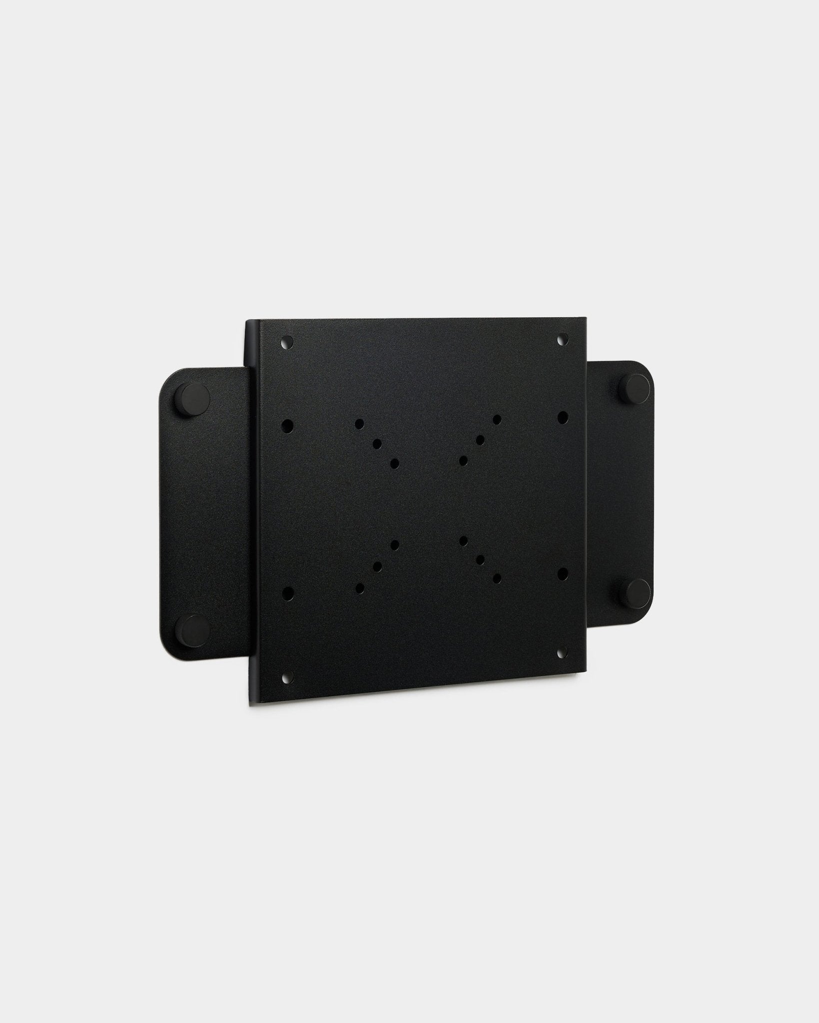 Il Fjell | TV Mount (small) di WoodUpp, una staffa in metallo black con più fori per viti e chiusura magnetica, mostrata su sfondo bianco.