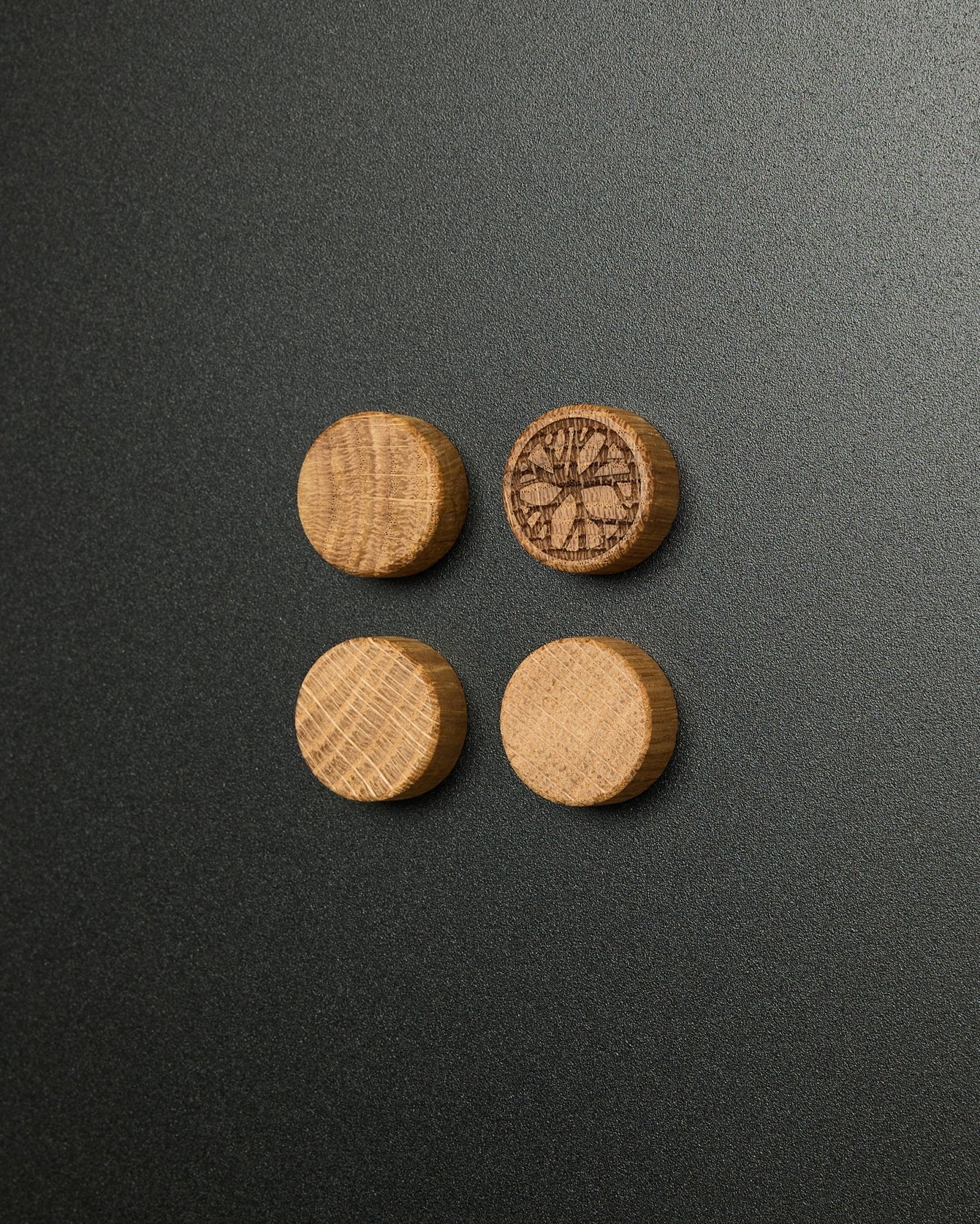 Set di quattro magneti in natural oak massello di WoodUpp, di cui uno con un design intagliato a fetta di agrume, pensati per l’uso con la Norr Magnetic Board Pannello acustico.
