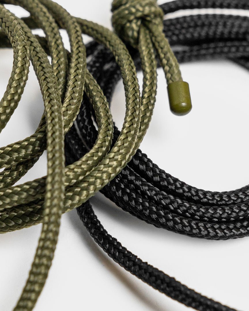 Vindar | Gallery String di WoodUpp: cordino intrecciato verde e black con terminali in plastica, mostrato accanto a un cordino per appendere foto su uno sfondo bianco.
