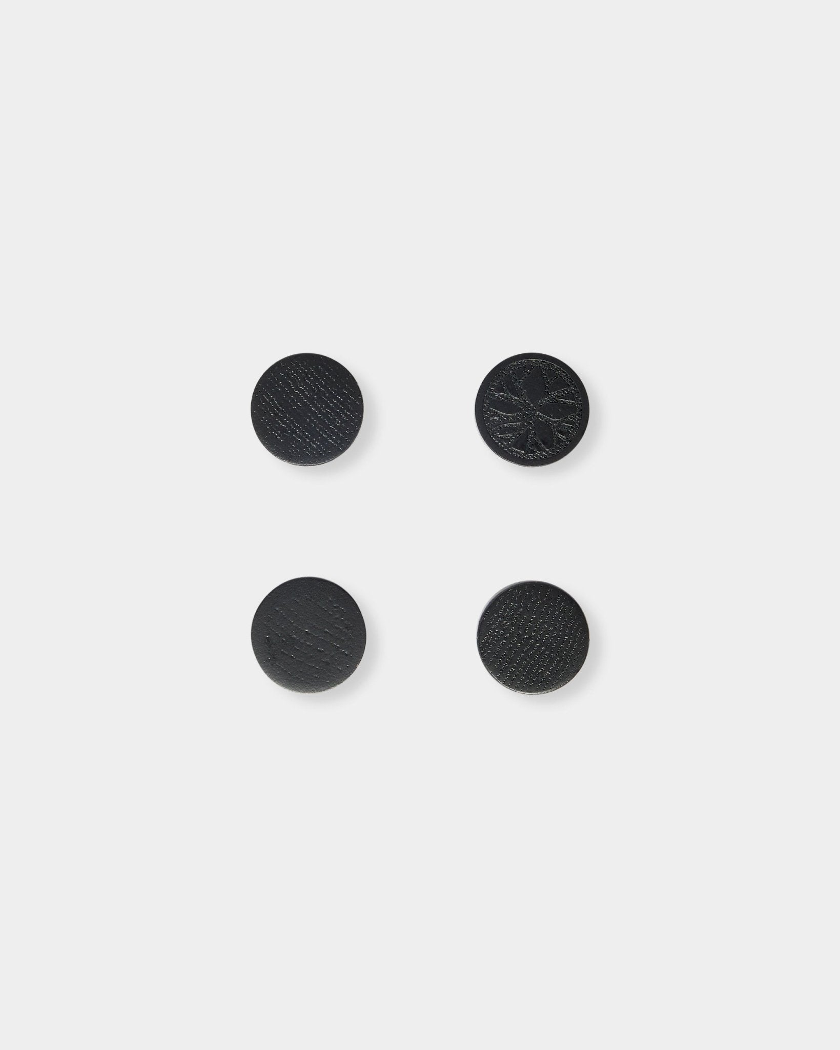 Set di quattro magneti black oak Norr di WoodUpp, disposti con ordine in un quadrato su uno sfondo semplice grigio chiaro.