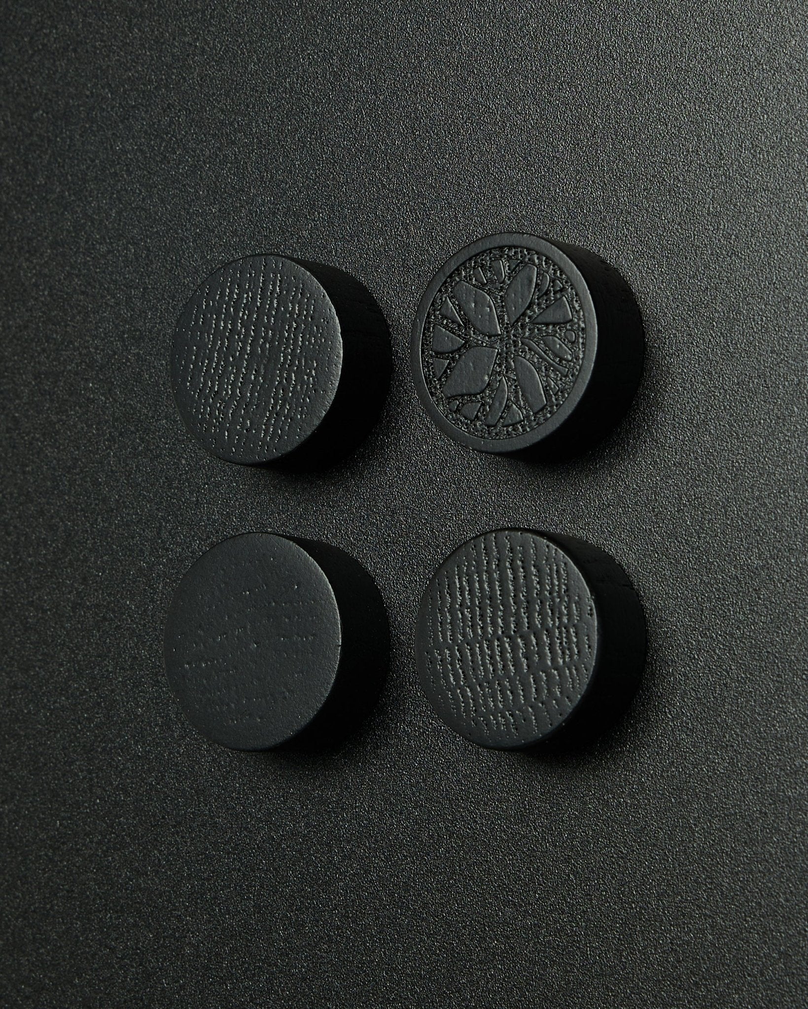 Set di 4 magneti rotondi black oak di WoodUpp, progettati per la lavagna magnetica Norr. Finitura opaca con una delicata texture del legno. Adatti come accessori Akupanel.