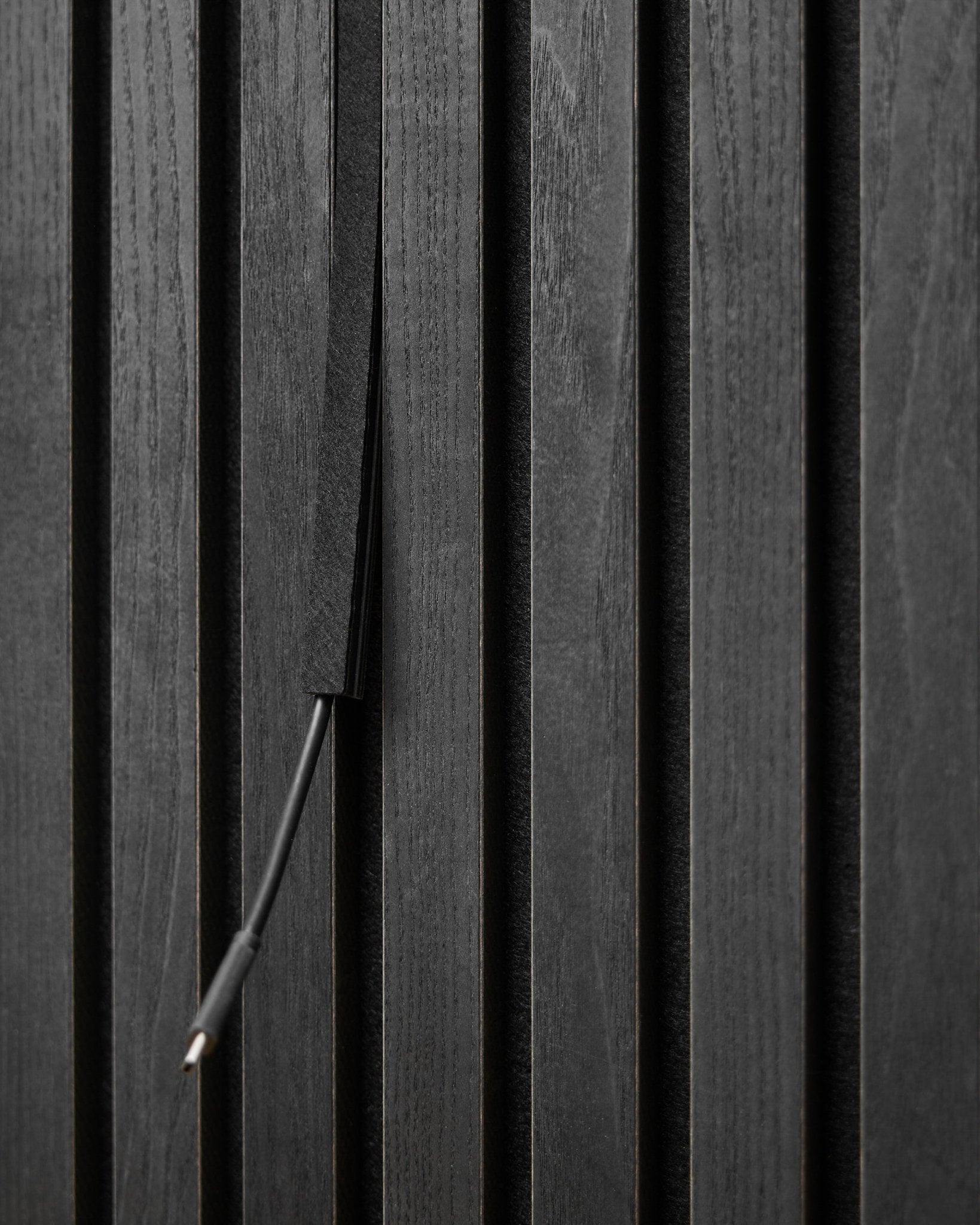 Il copricavo Pop-on Dupps (Black, 3 pz) di WoodUpp nasconde i cavi tra le doghe Akupanel Pannello acustico per un aspetto ordinato e integrato.