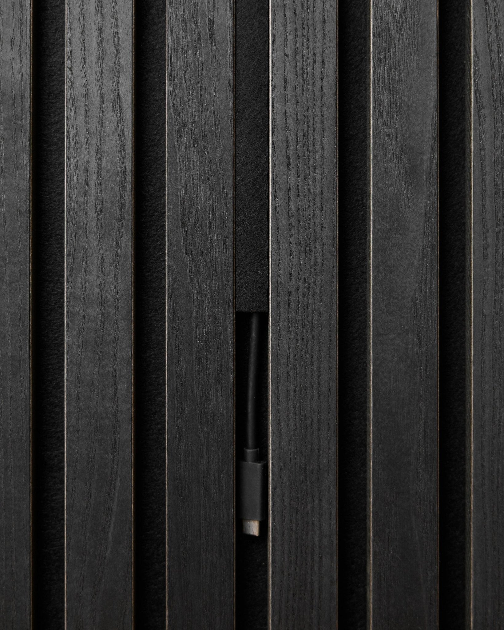 I copricavi Pop-on WoodUpp Black (3 pz) nascondono con ordine i cavi dietro i pannelli acustici in legno Akupanel, mantenendo un look nordico pulito e continuo.