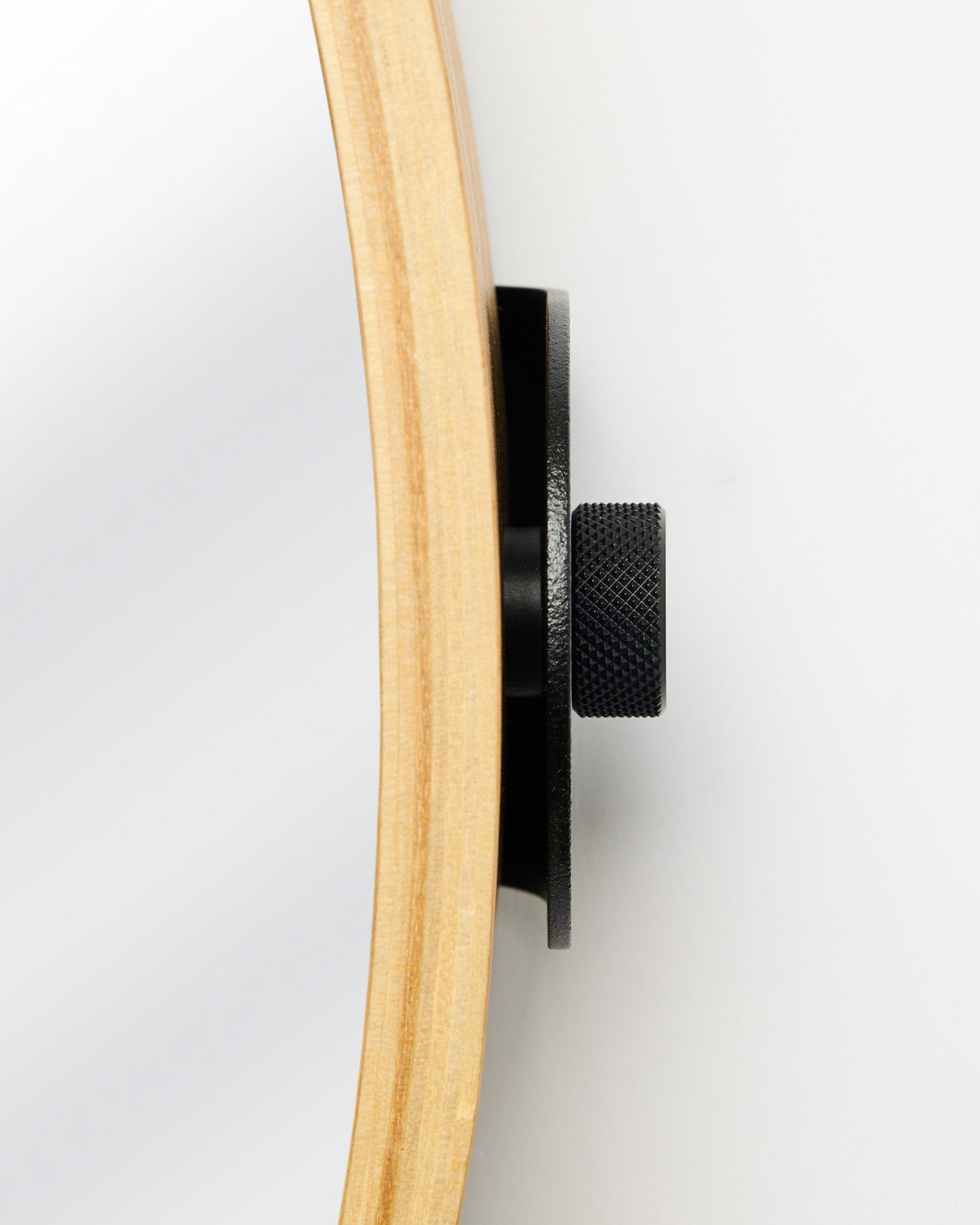 Vista laterale ravvicinata del Linn | Mirror di WoodUpp in Natural Oak, con una cornice rotonda in compensato Rovere e un pomello in metallo black, accessorio per pannelli acustici in legno.