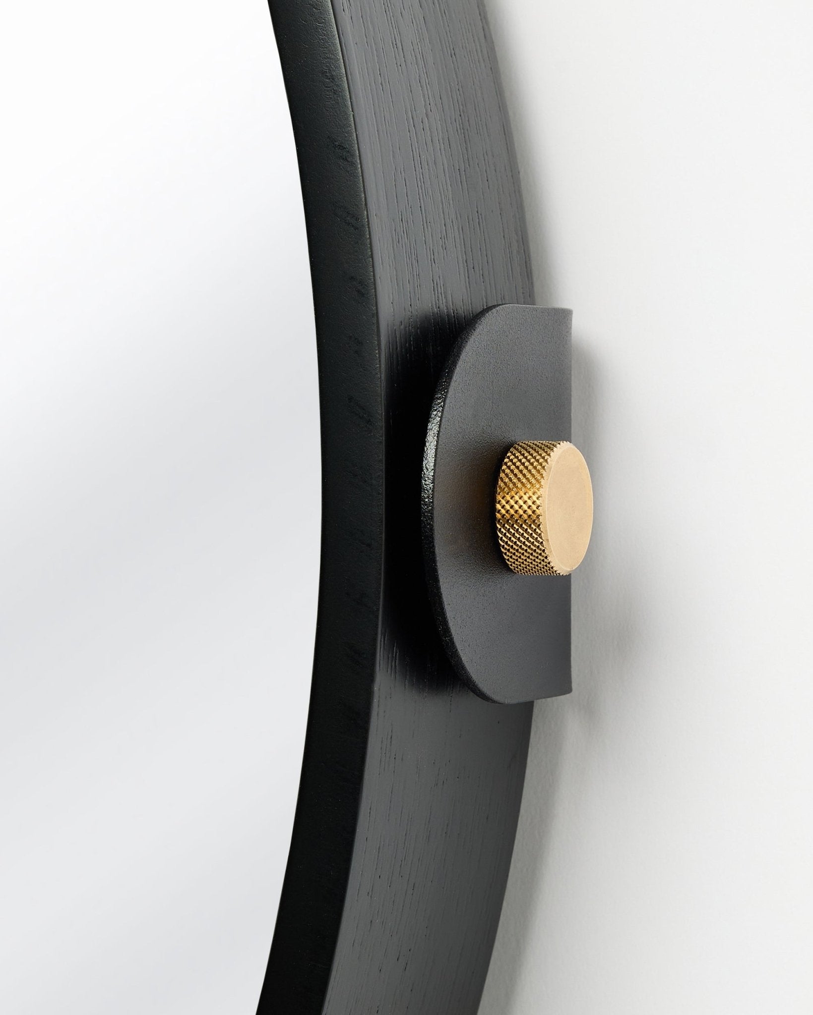 Dettaglio del Linn | Mirror / Black Oak Pannello acustico di WoodUpp, montato a parete con manopola dorata e inclinazione regolabile.