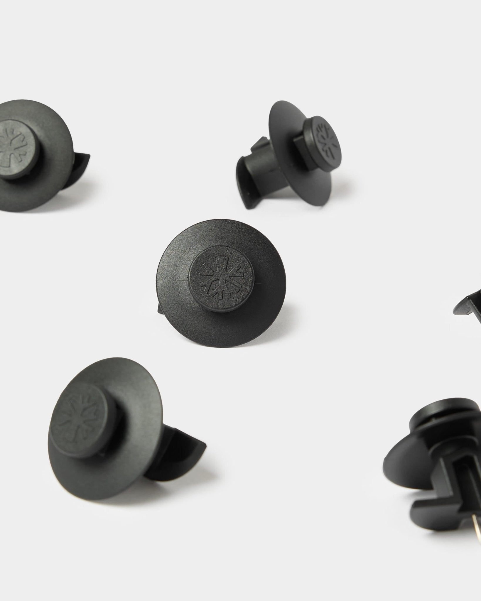 10 elementi di fissaggio Dupps neri di WoodUpp, compatibili con i pannelli acustici Akupanel per un montaggio sicuro. Simboli in rilievo su plastica resistente.