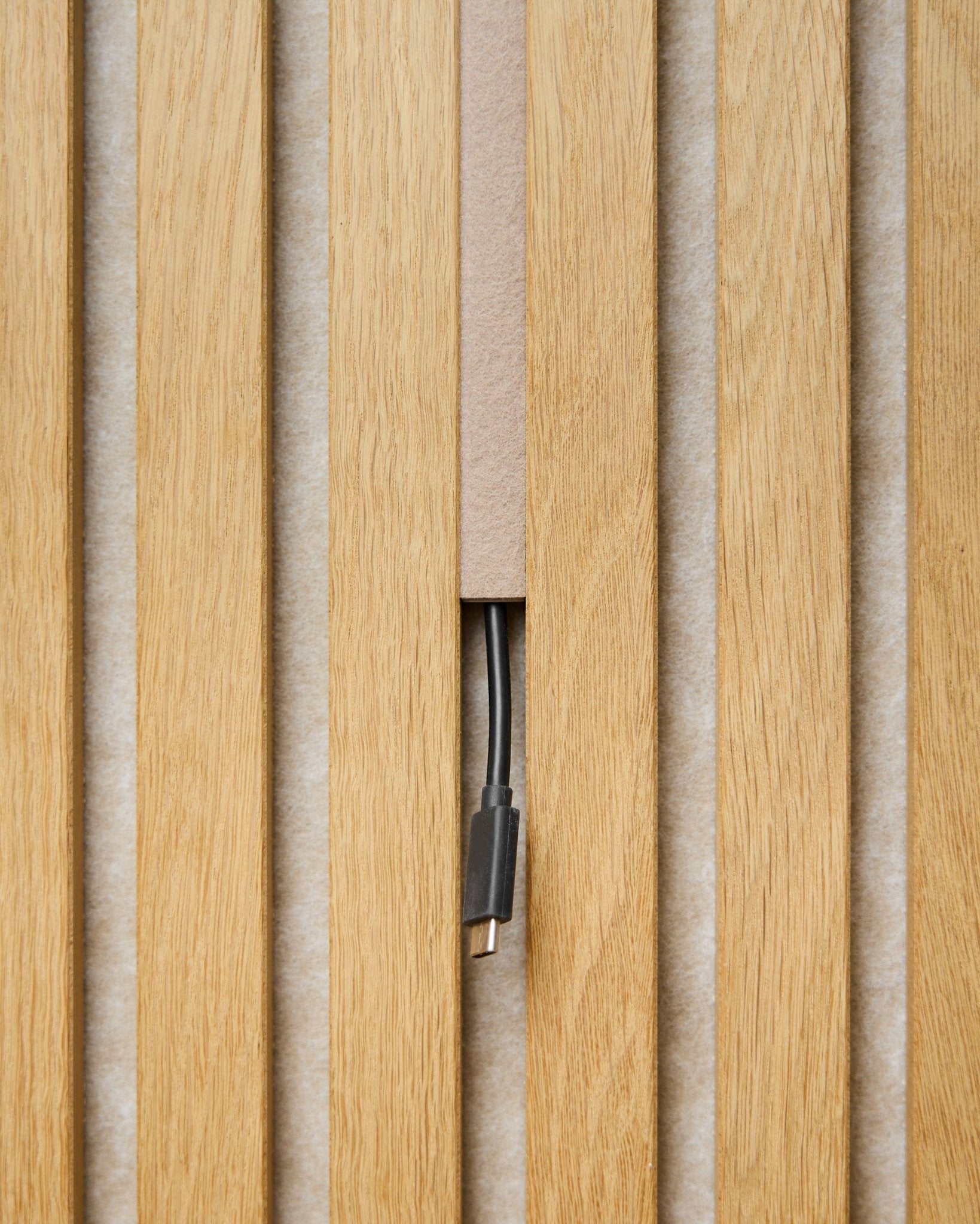 Il copricavo Pop-on Dupps (beige, set da 3) di WoodUpp nasconde i cavi tra Pannello acustico doghe, lasciando visibile solo il connettore per una finitura pulita.