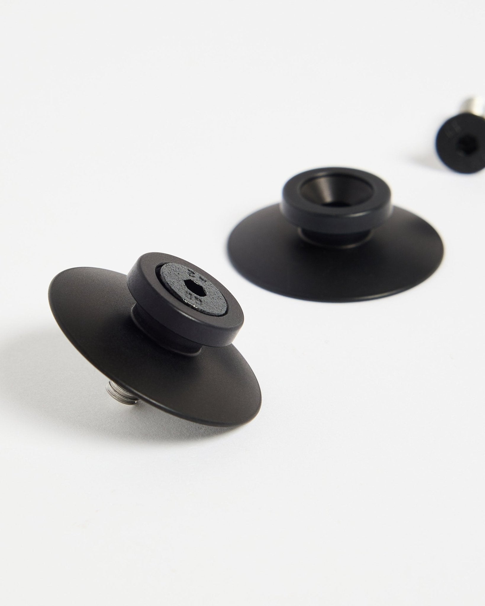 Due fissaggi WoodUpp in alluminio Dupps black (2 pz) su una superficie bianca, progettati per montare in modo sicuro pannelli acustici o divisori per ambienti.