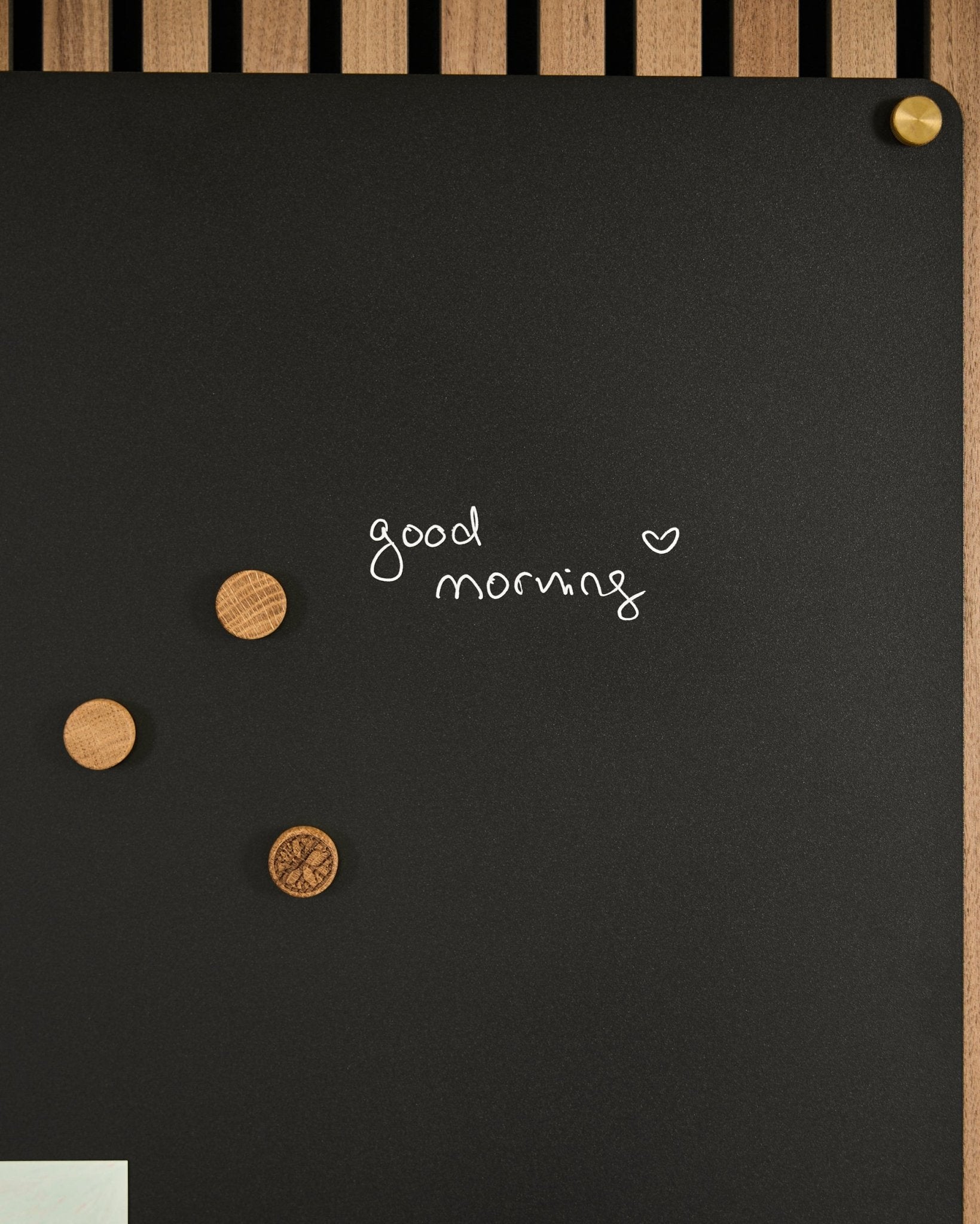 Il Norr | Blackboard set di WoodUpp presenta un black Pannello acustico con la scritta good morning e un cuore, oltre a 3 magneti in legno. Design nordico minimalista.