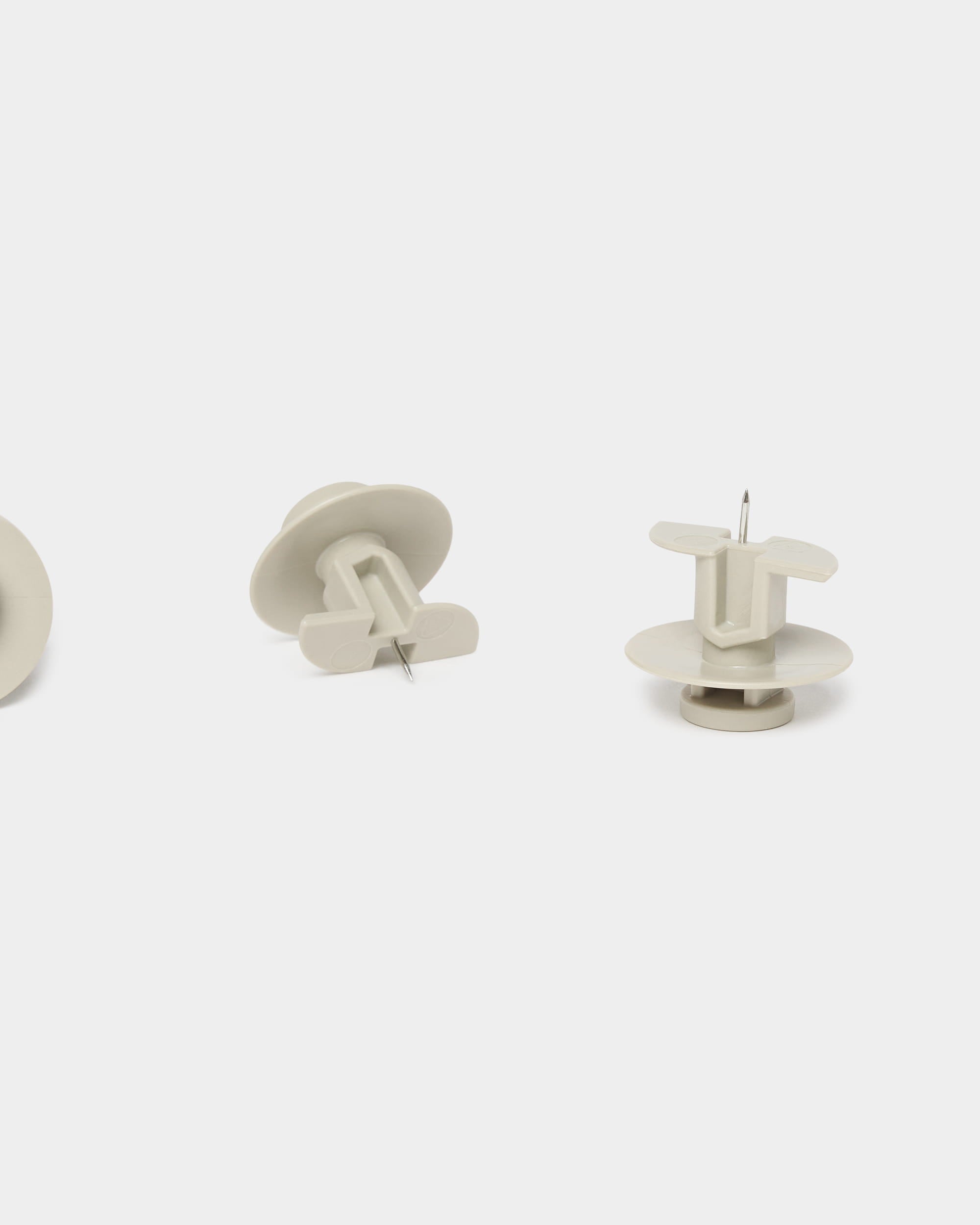 Set composto da tre puntine da disegno WoodUpp Dupps color beige e da un attrezzo, progettato per i pannelli acustici Akupanel, raffigurati in posizione verticale e laterale su uno sfondo bianco semplice.