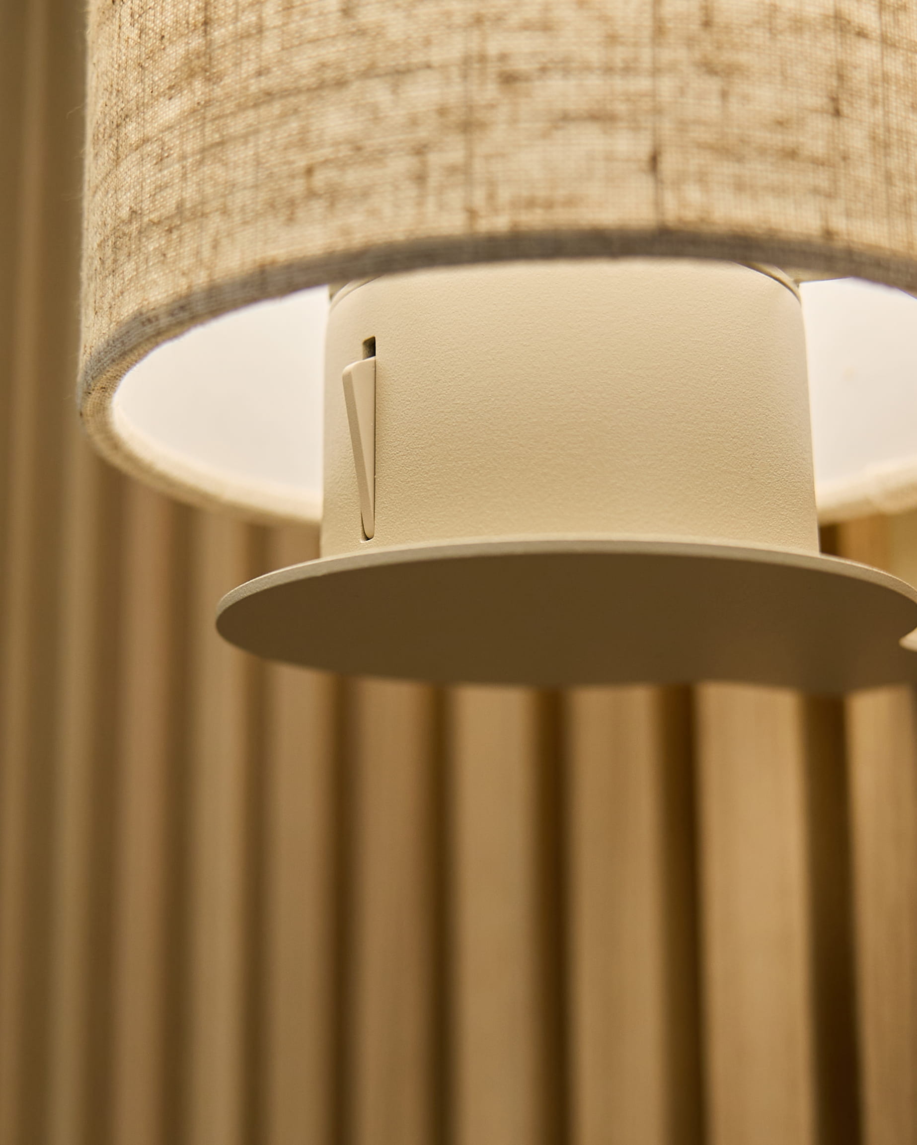 Primo piano della Feya Wall Lamp in Beige/Beige di WoodUpp, con paralume in lino-cotone e struttura cilindrica montata su pannelli acustici beige vertical.
