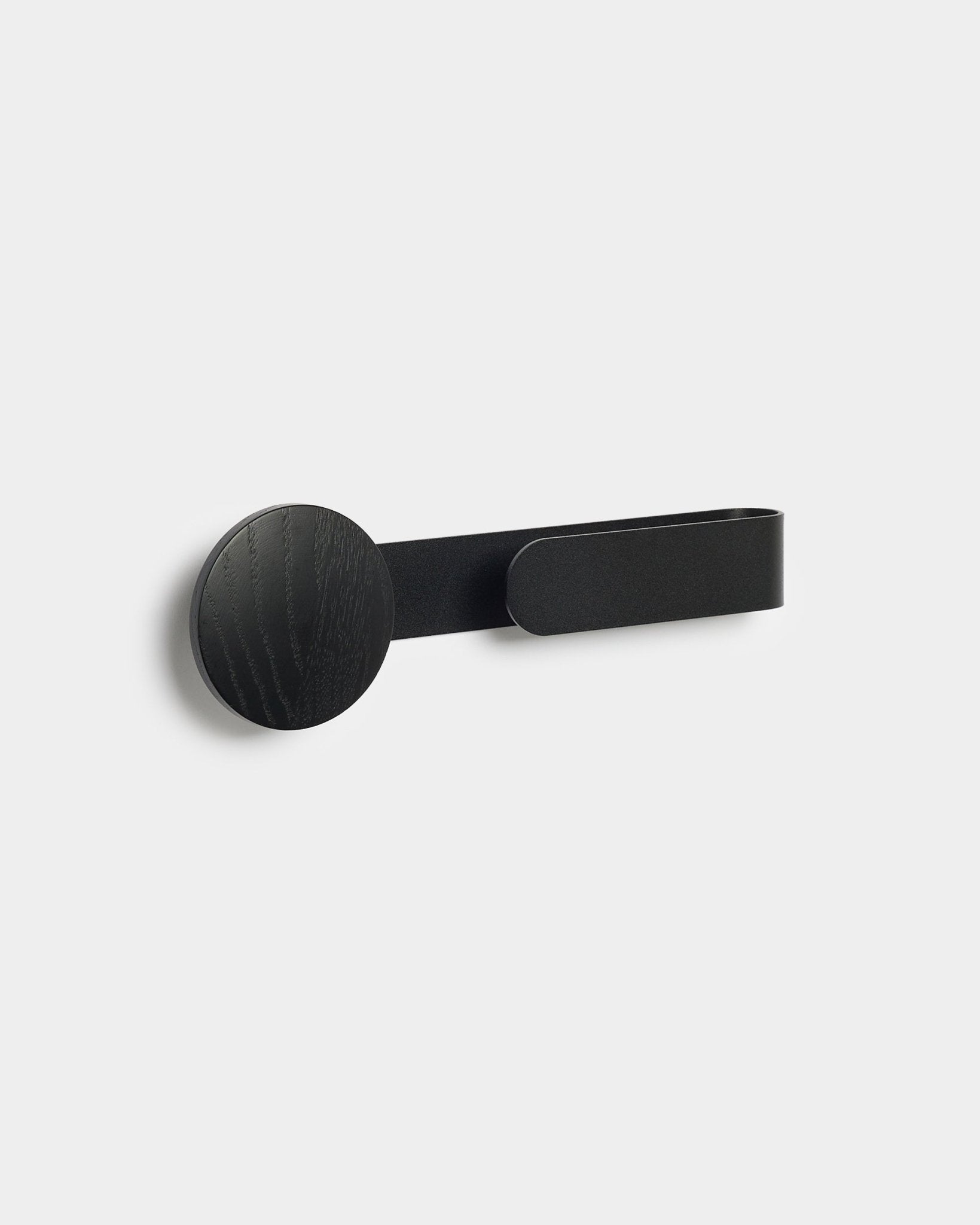 Il gancio Linn | Horizontal in Black Oak di WoodUpp, un accessorio minimalista in black verniciato a polvere in steel e legno, su uno sfondo chiaro grey.