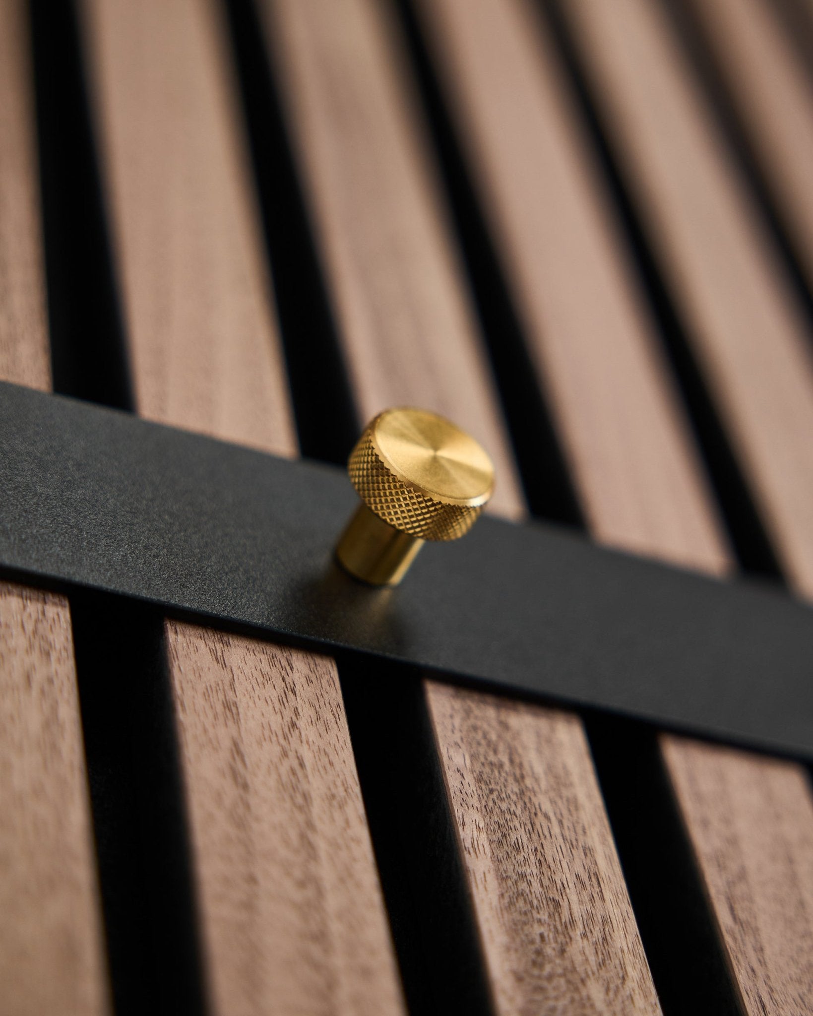 Il Coat Hook Rack WoodUpp Norr presenta sette ganci black con pomelli brass, montati su un pannello a listelli brown, pensato come accessorio nordico per Akupanel.