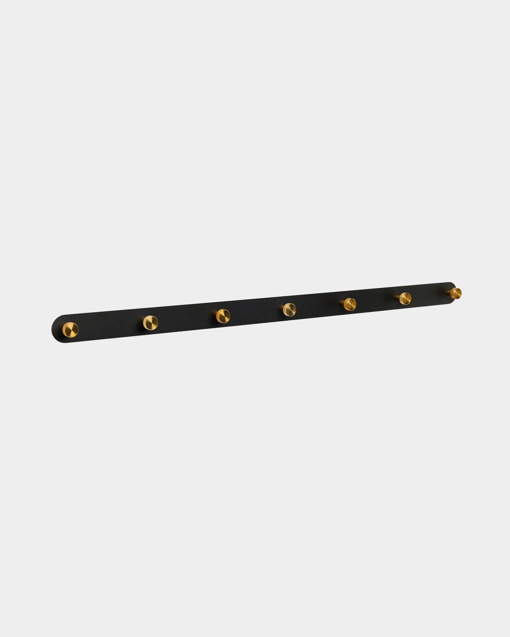 Appendiabiti Norr di WoodUpp con 7 ganci brass su un black Pannello acustico, pensato come soluzione da corridoio compatibile con le collezioni Akupanel.