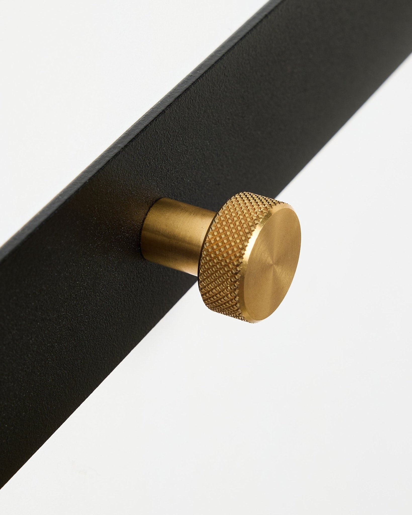 Primo piano dell’appendiabiti Norr Coat Hook Rack X5 di WoodUpp, con black verniciato a polvere steel e pomelli rotondi testurizzati brass, su sfondo bianco.