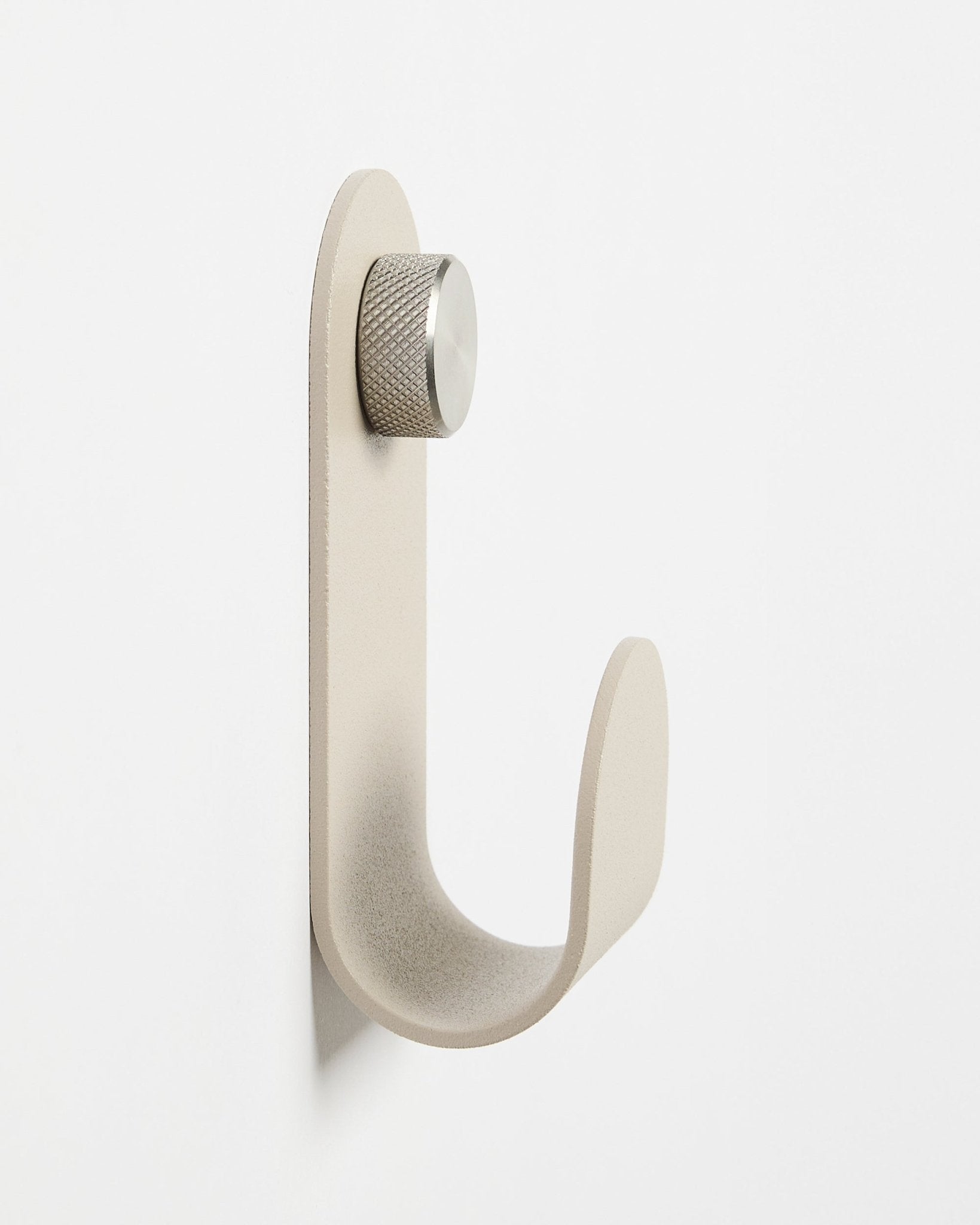 Il Norr | Single Hanger in Beige di WoodUpp, un accessorio minimalista da parete con pomello argentato, progettato per completare i pannelli acustici in legno Akupanel.