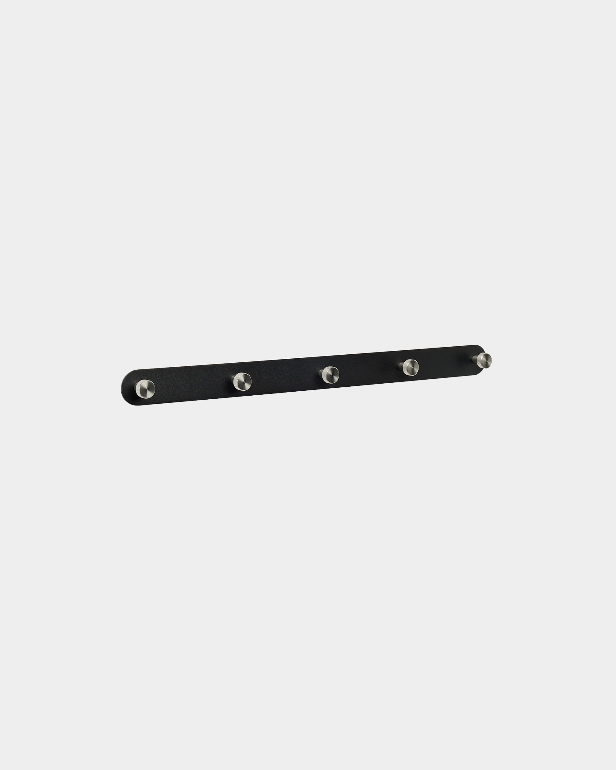Appendiabiti WoodUpp Norr X5 in black e steel inox, con cinque ganci equidistanti, montato su uno sfondo bianco semplice. Design nordico minimalista.