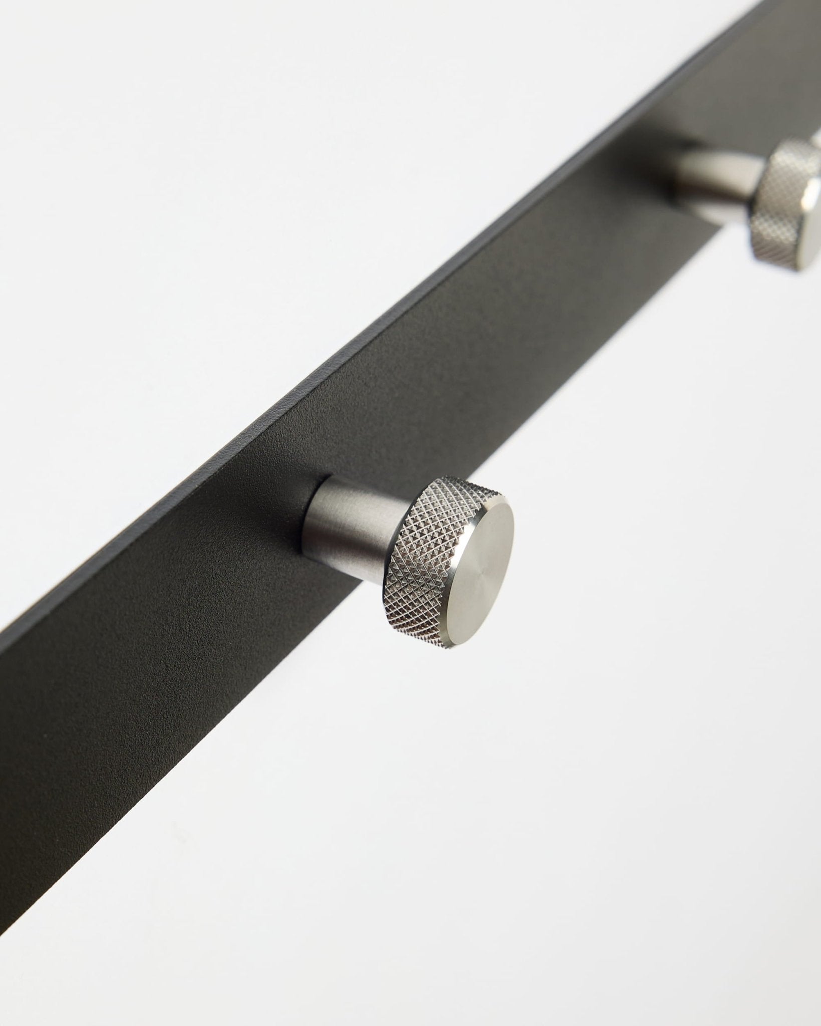 Primo piano di Norr | Coat Hook Rack / X5 di WoodUpp in black e acciaio inox steel, progettato come accessorio per i pannelli acustici Akupanel o per l’ingresso.