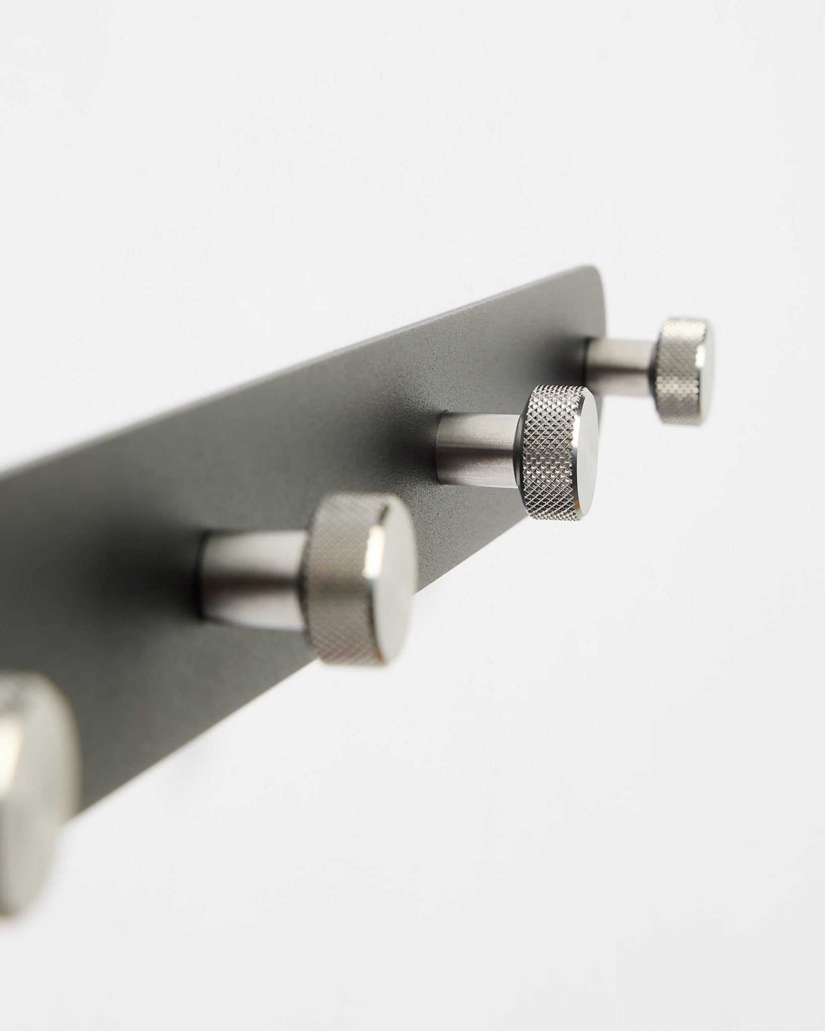 L’appendiabiti a ganci WoodUpp Norr Coat Hook Rack X7 in nero e acciaio inox con sette ganci, mostrato su uno sfondo bianco semplice; parte della collezione di accessori CREATE.